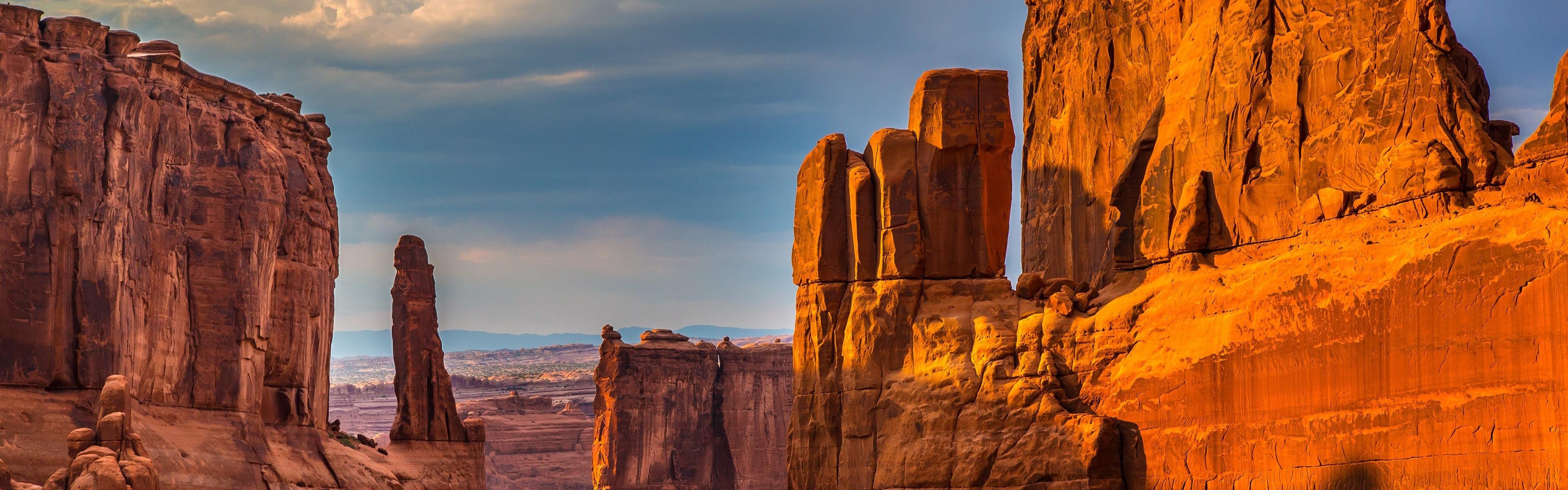 Desert canyon with rock formations under a clear sky HD Wallpaper