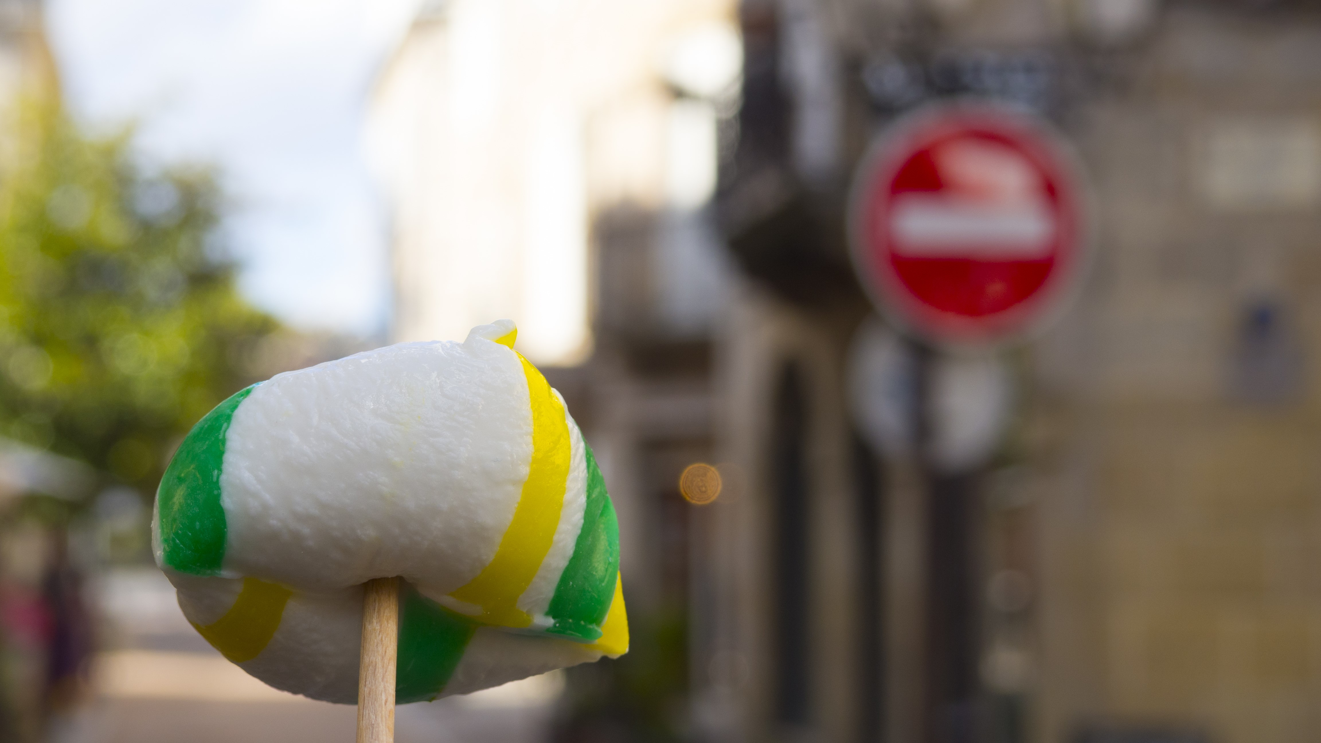 Candy on a stick with blurred city background HD Wallpaper