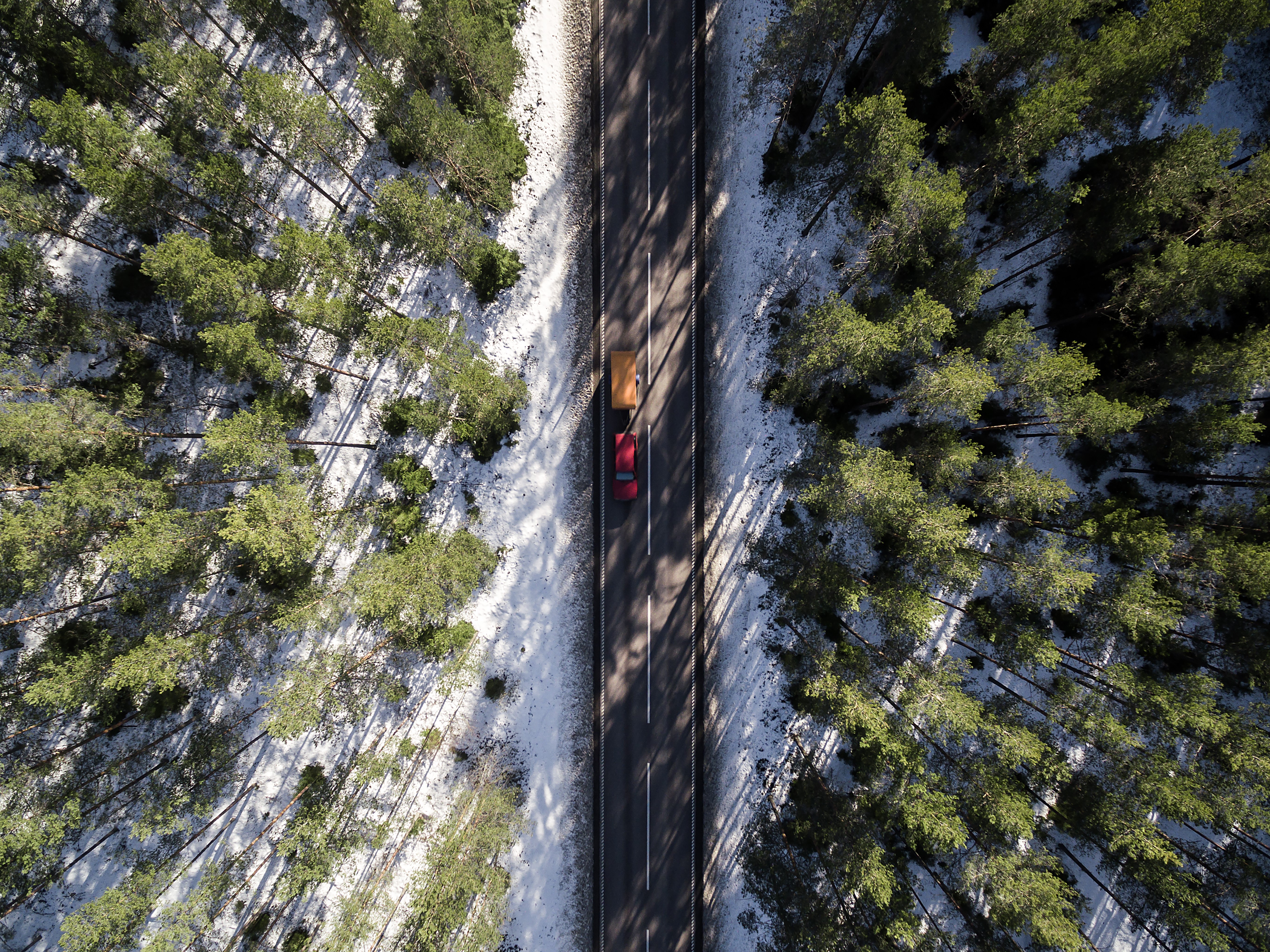 Aerial view of car and trailer on snowy forest road HD Wallpaper