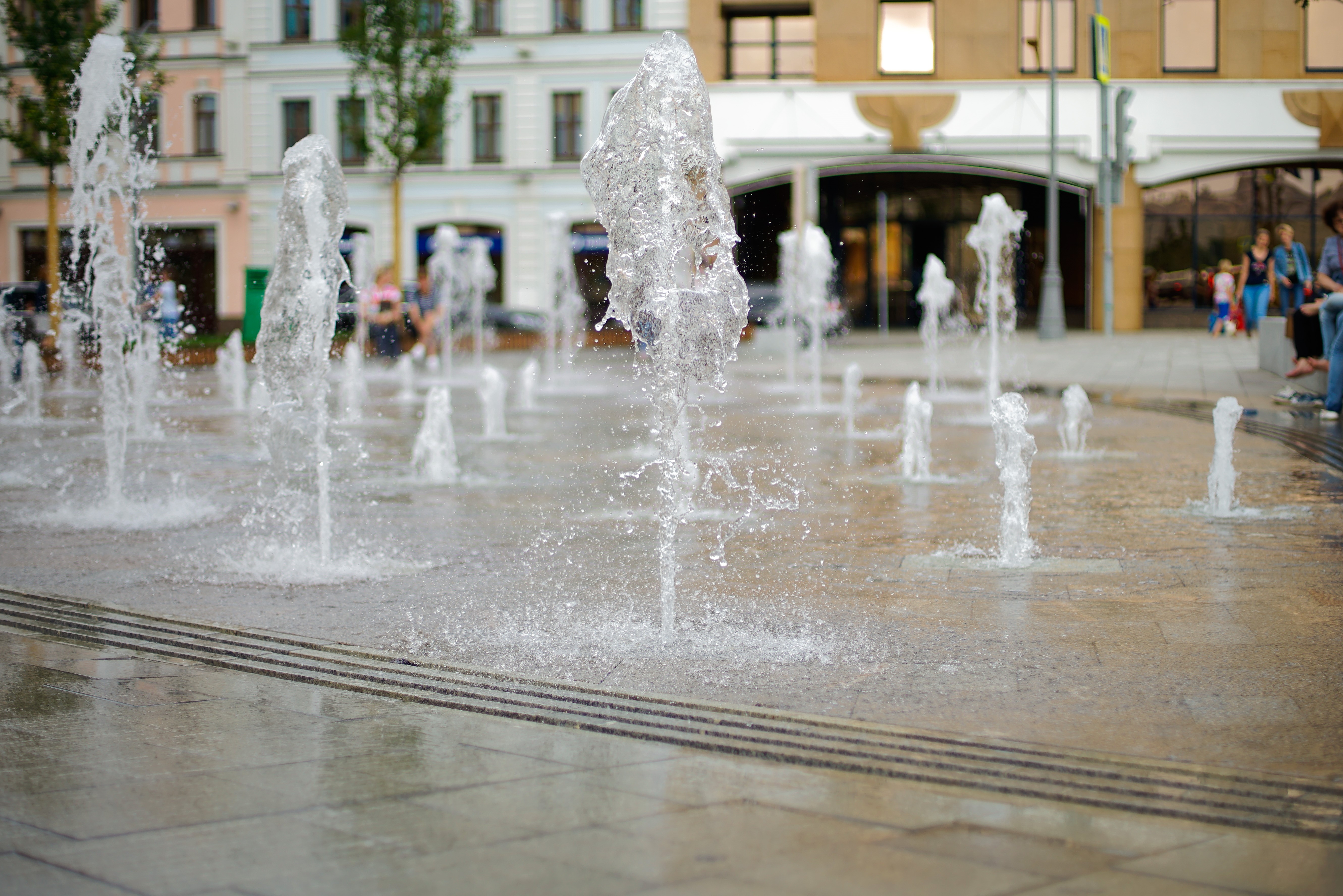 Fountain with water drops in a city square HD Wallpaper