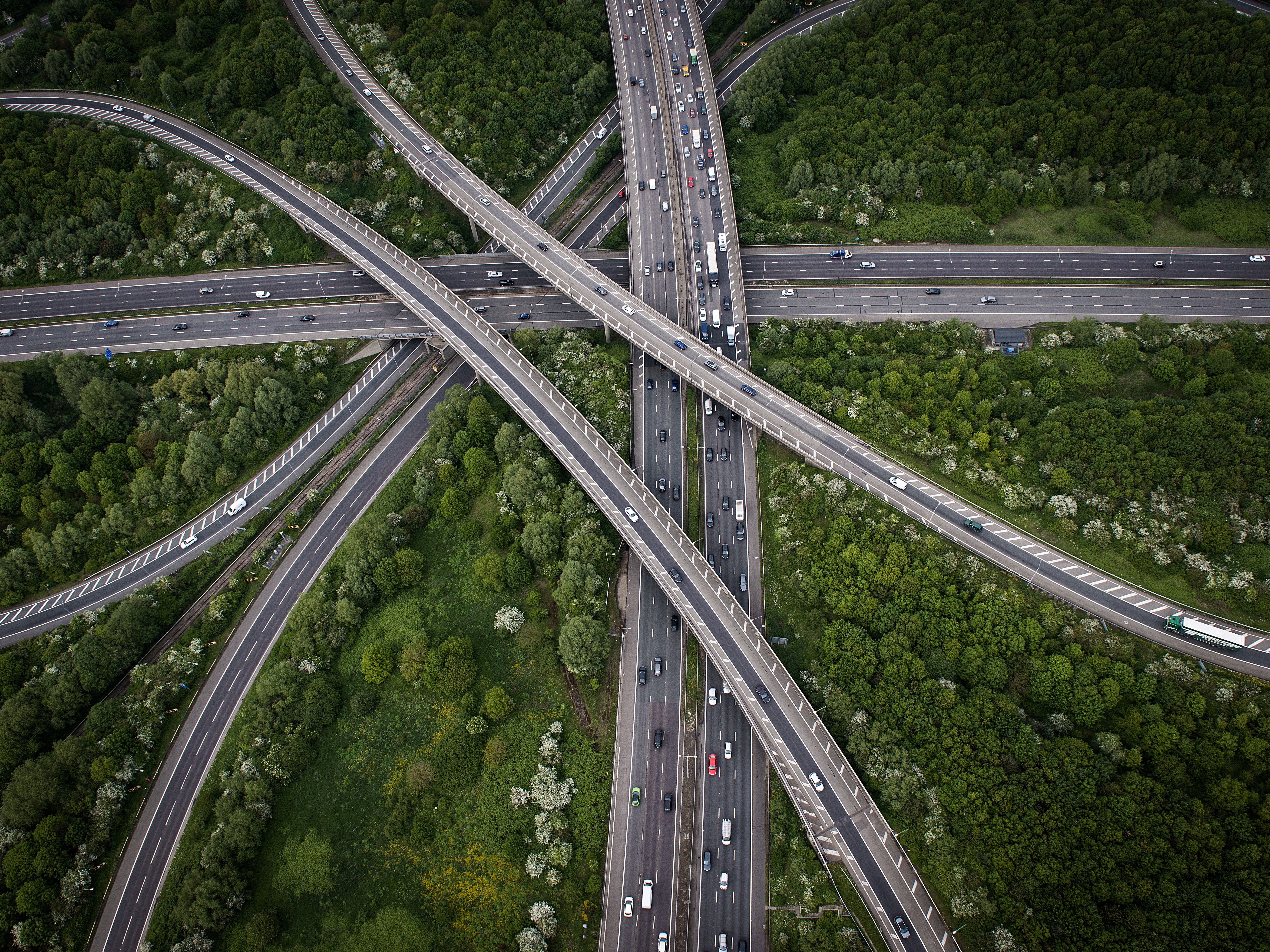 Aerial view of a complex highway interchange with traffic HD Wallpaper