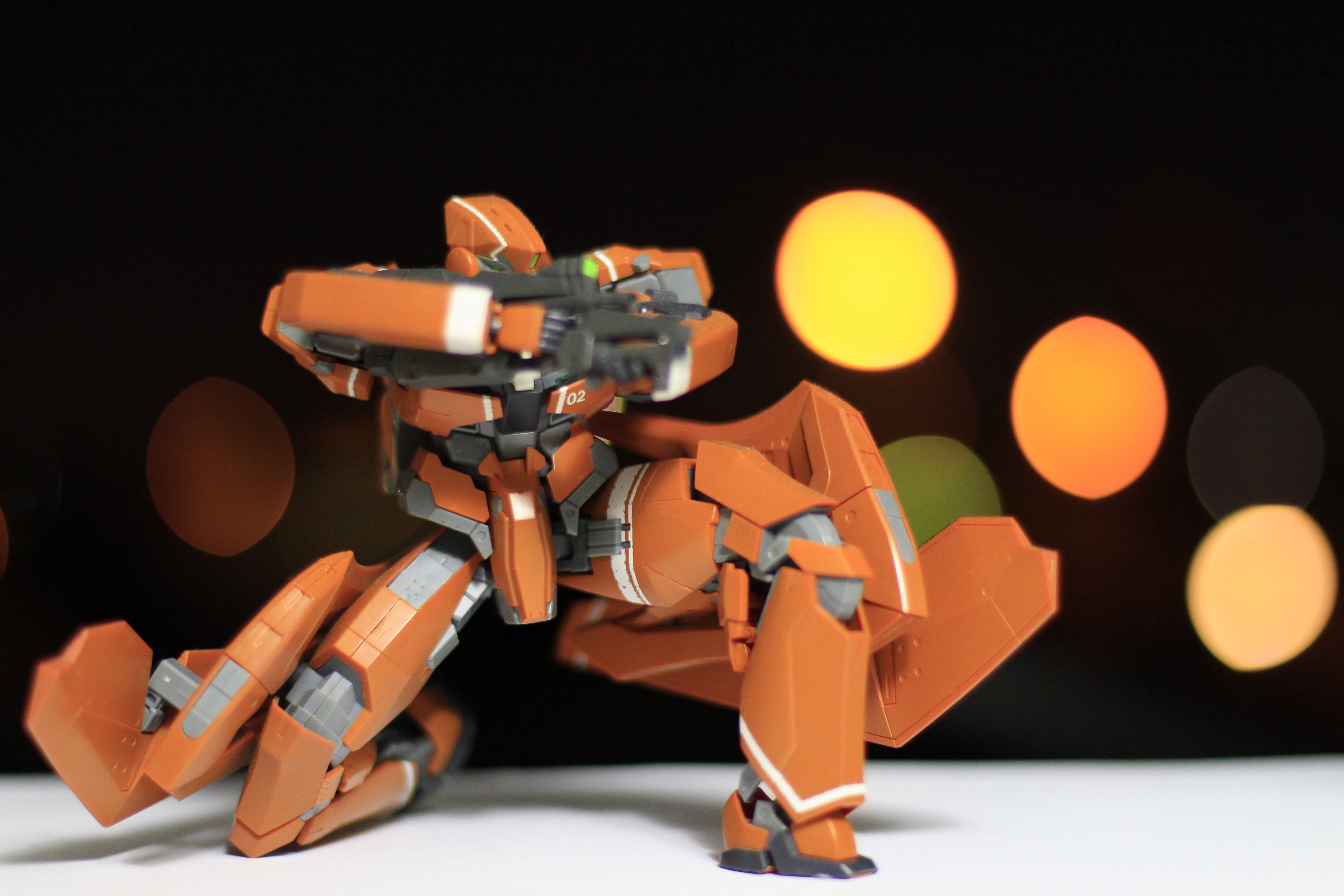 Orange robot with gun, bokeh background HD Wallpaper