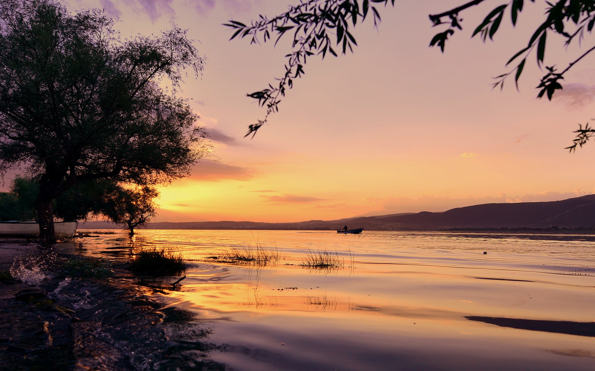 Sunset over a calm lake with a lone boat HD Wallpaper