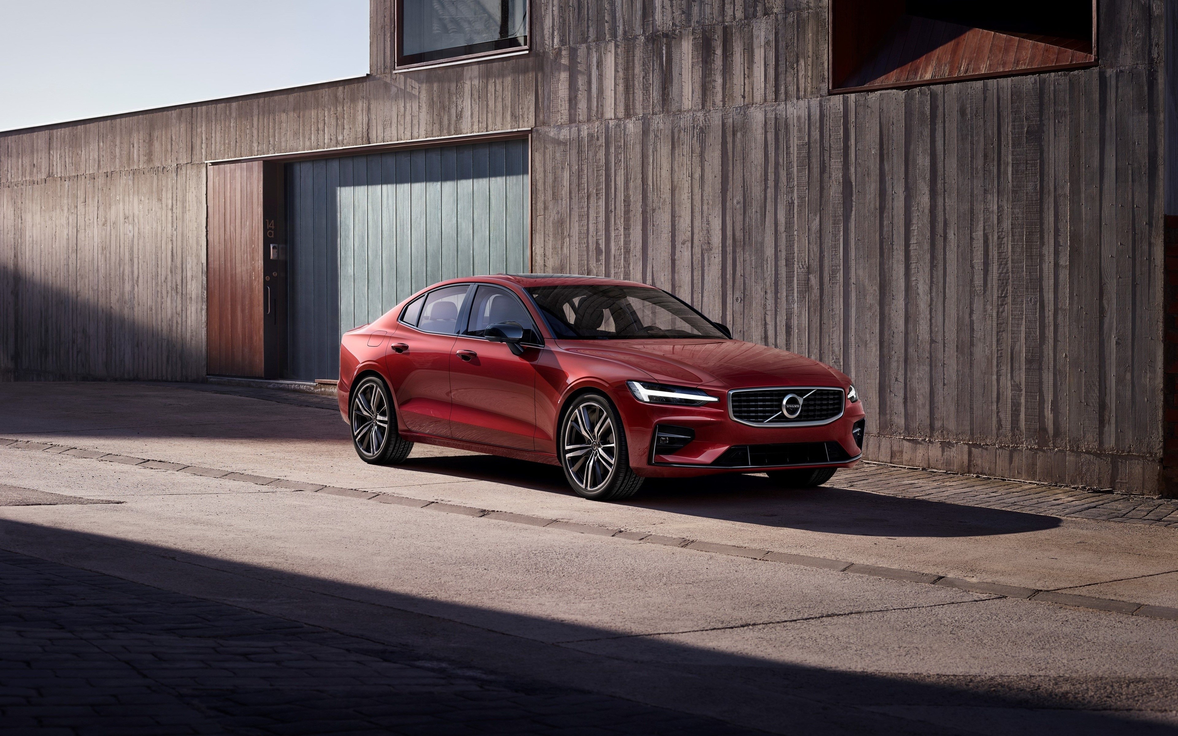 Red Volvo S60 Sedan parked near a concrete building HD Wallpaper
