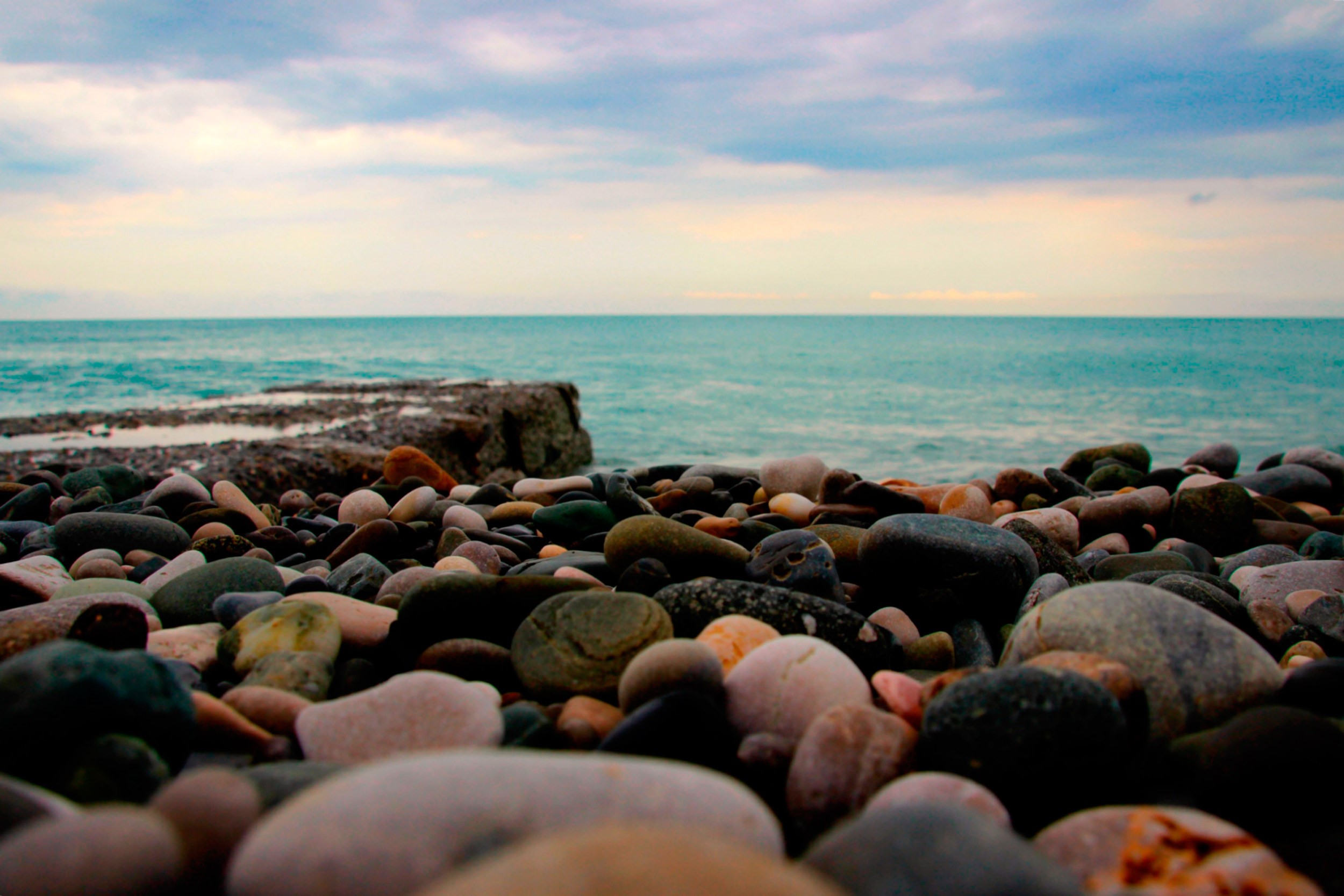 Pebbles on a Calm Beach Coast at Horizon HD Wallpaper