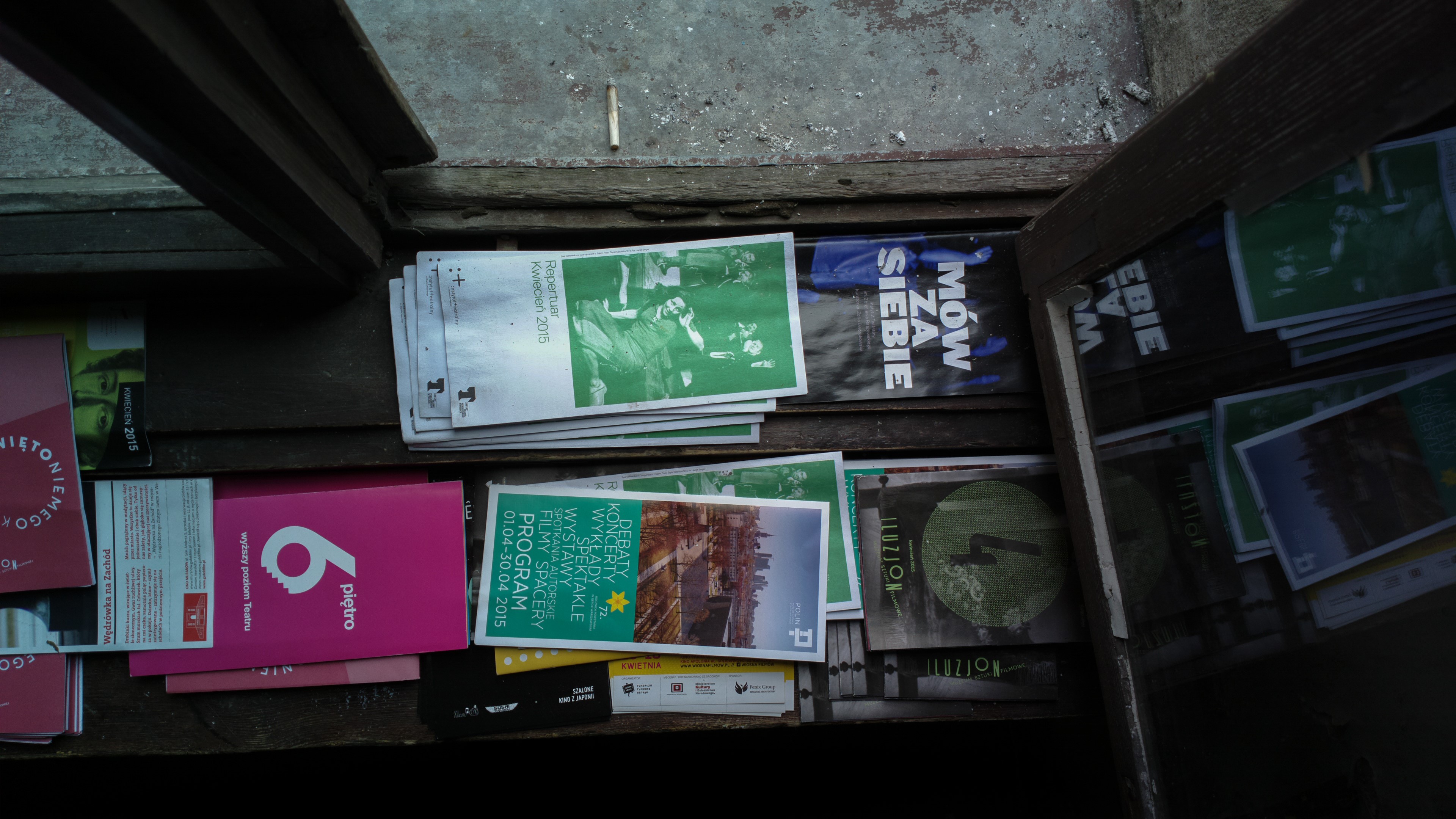 Posters and brochures on a wooden shelf HD Wallpaper