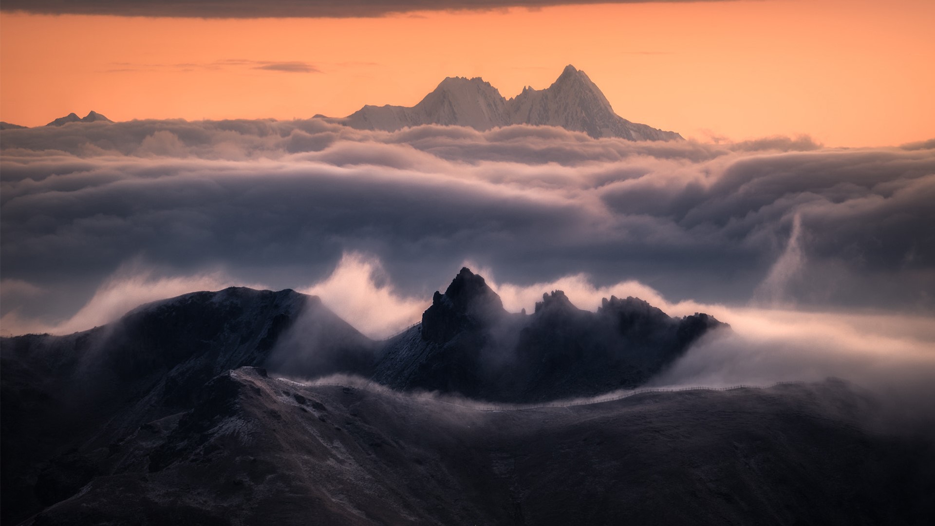 Mountains shrouded in mist at sunset HD Wallpaper
