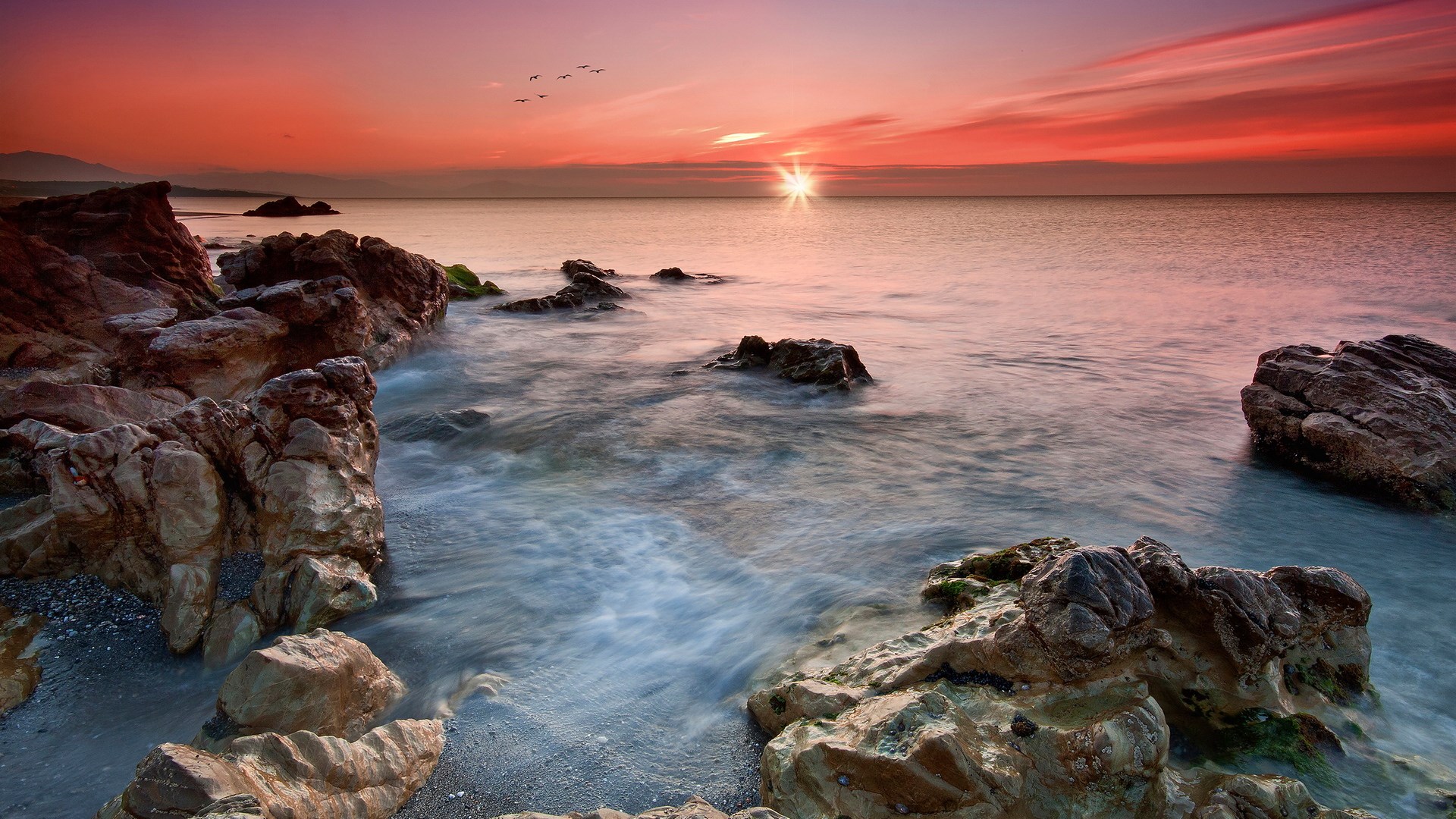 Sunset over the ocean with rocky shore HD Wallpaper
