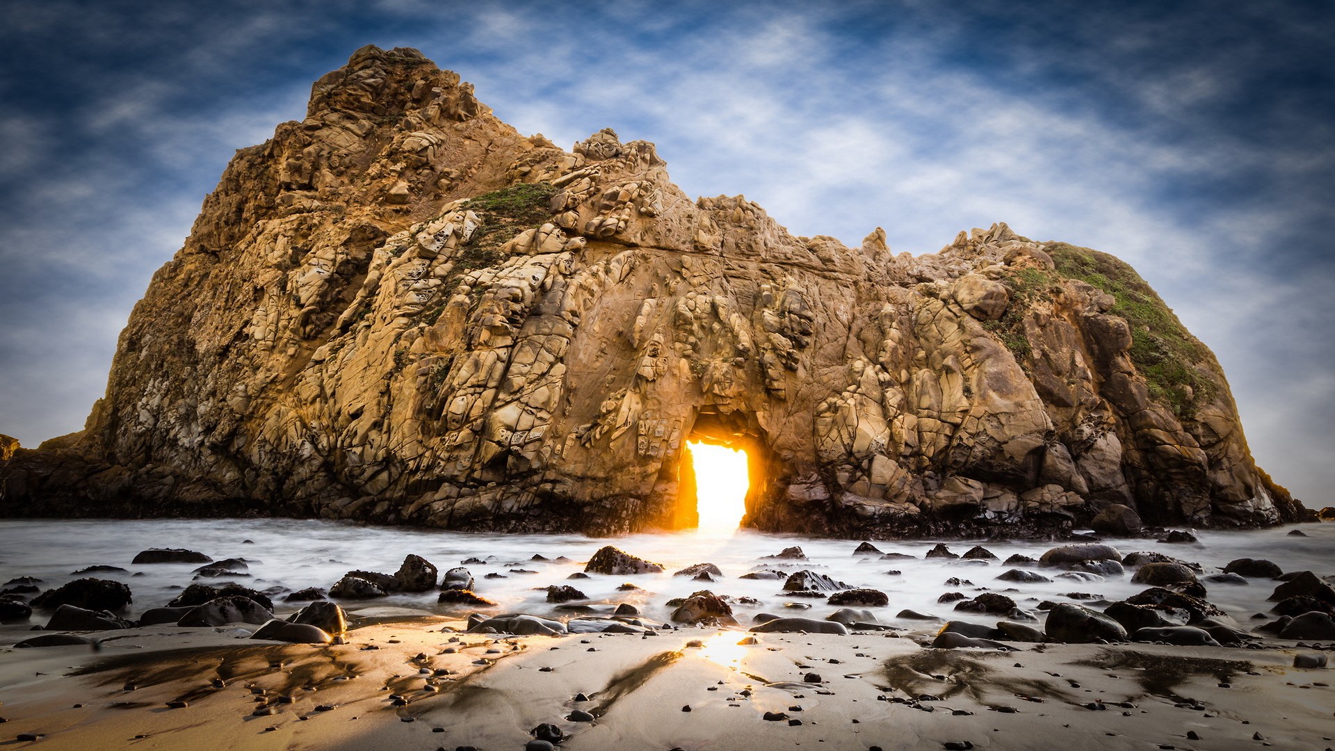 Archway in a rock formation on a beach HD Wallpaper