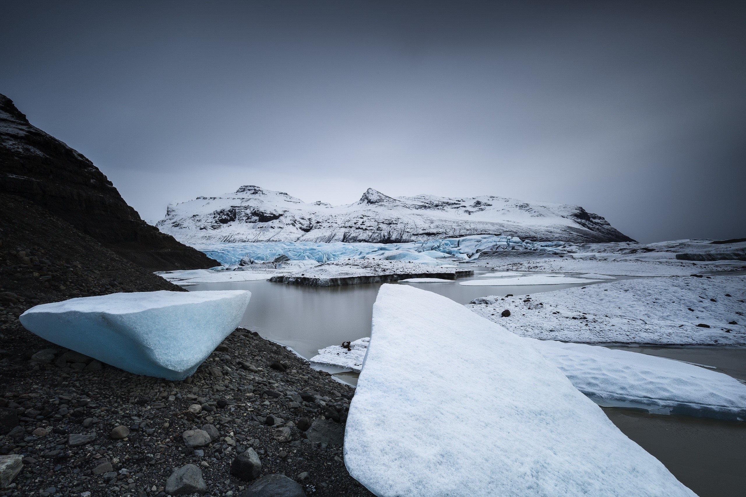 Icebergs on a glacial lake with snow-capped mountains HD Wallpaper