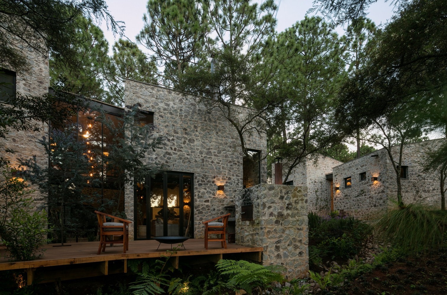 Stone building with large windows surrounded by trees HD Wallpaper