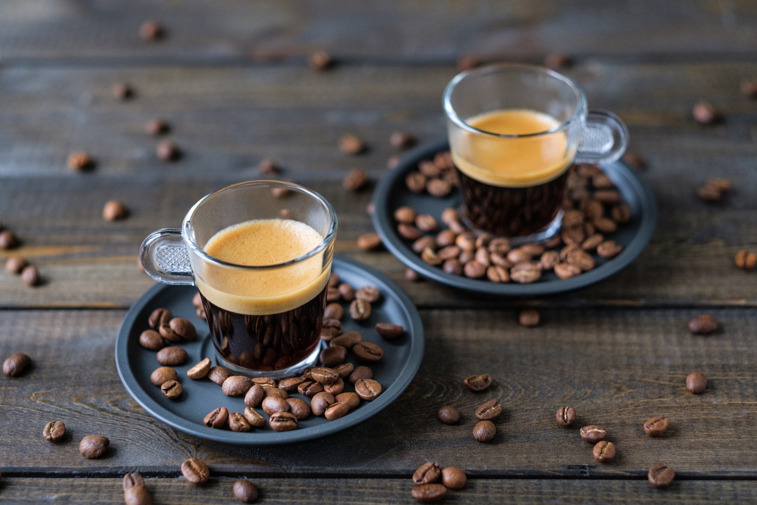 Two cups of espresso with coffee beans HD Wallpaper