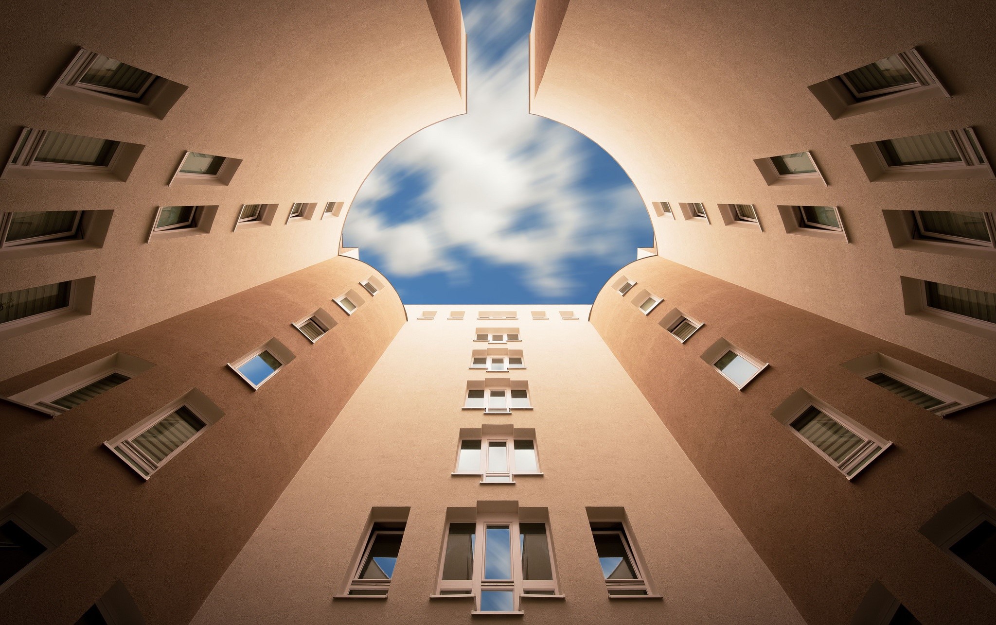 Looking up at a building courtyard with a sky view HD Wallpaper