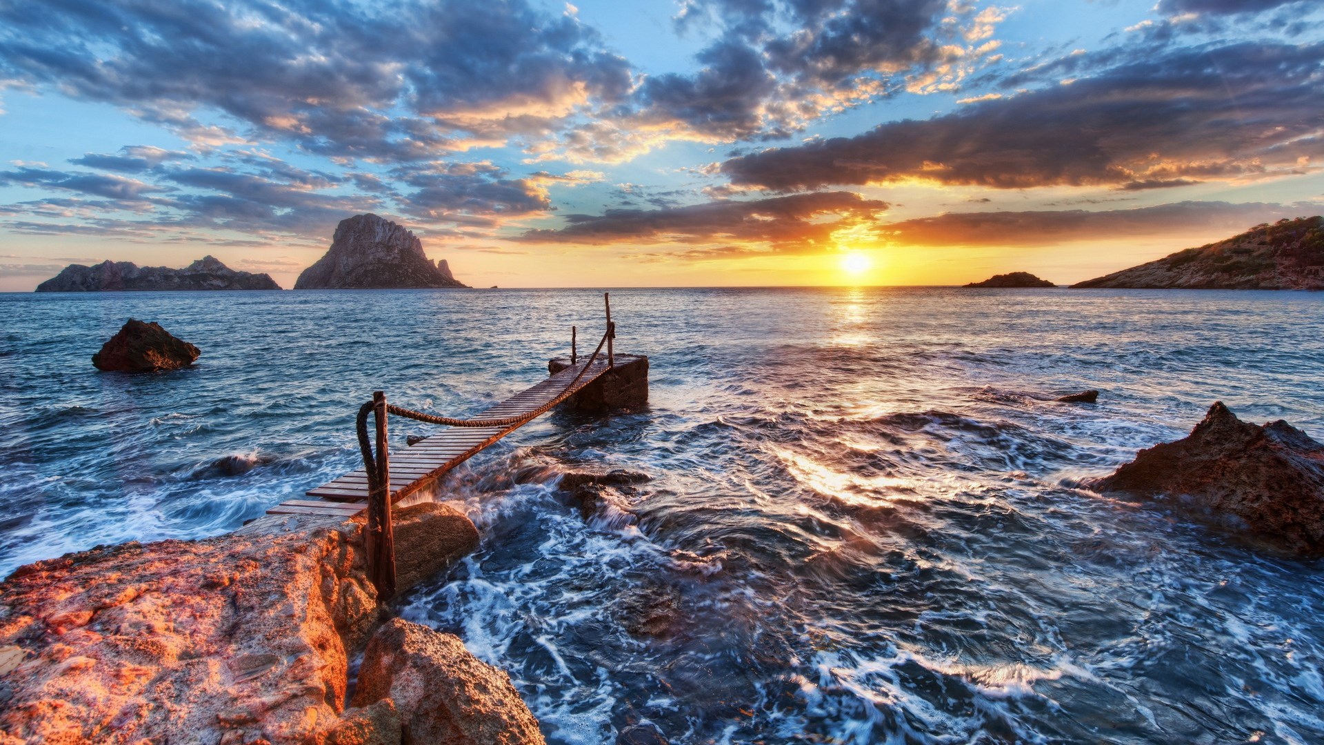 Sunset over the sea with a wooden pier and islands HD Wallpaper