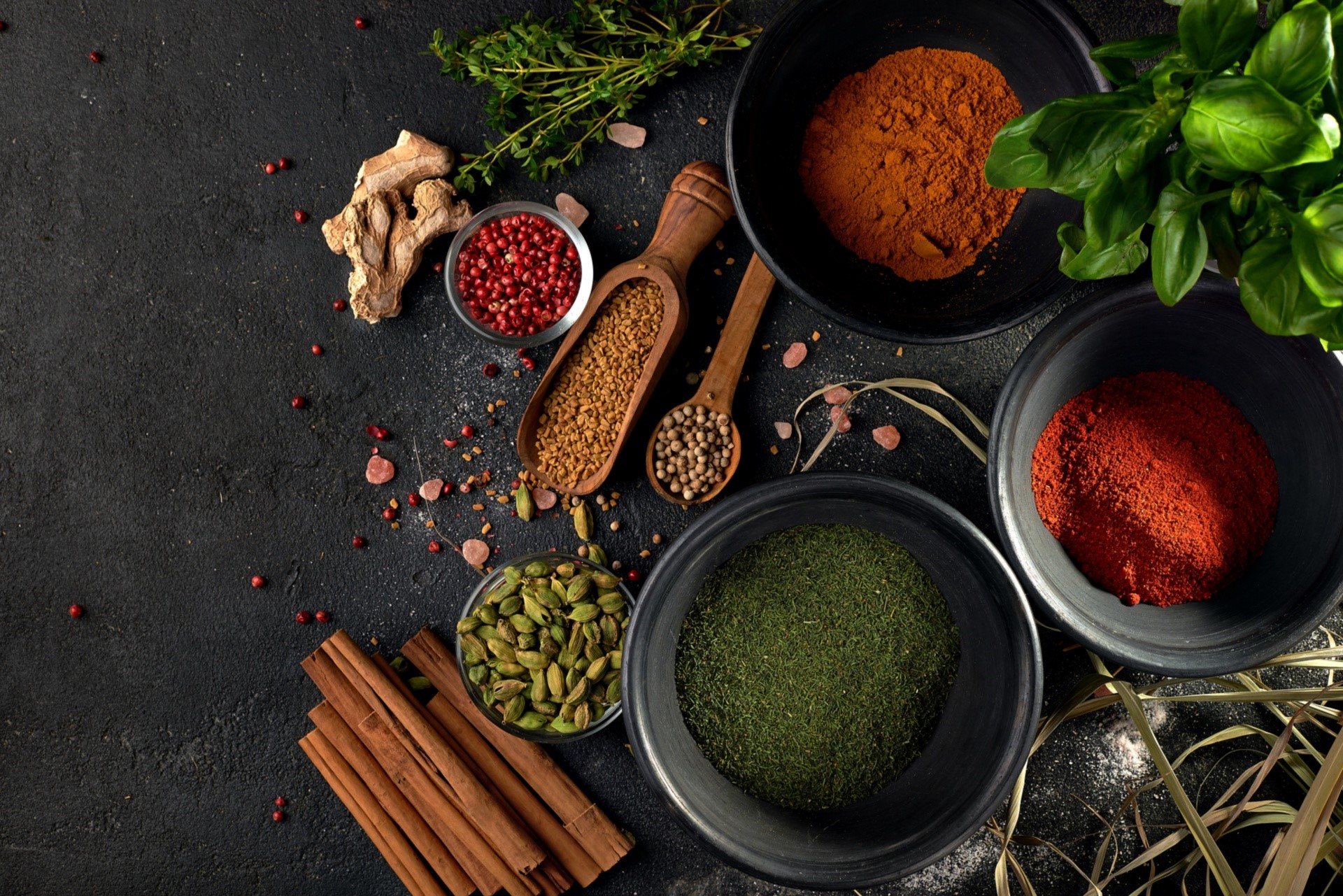 Assortment of spices and herbs on a dark surface HD Wallpaper