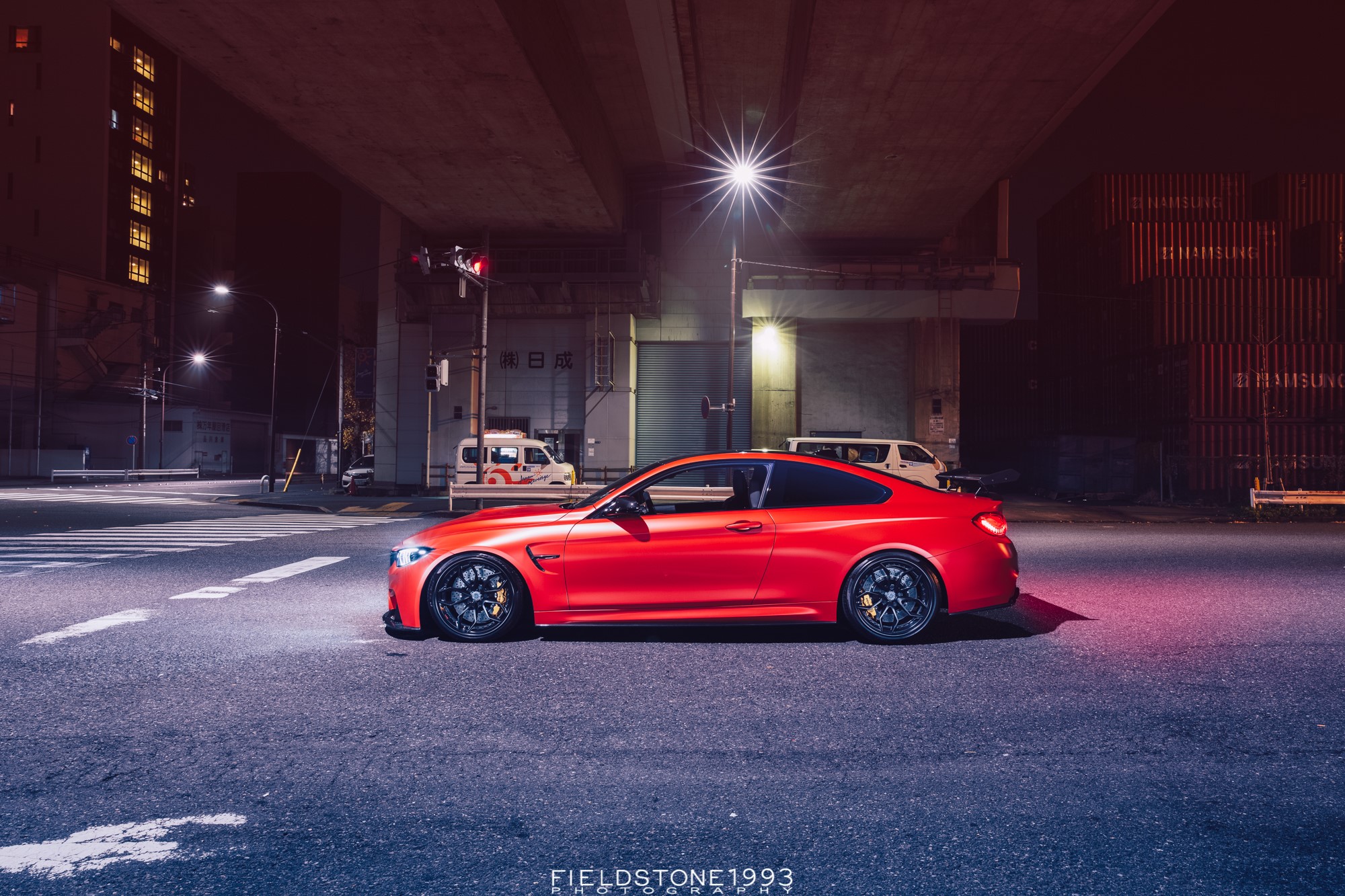 Red BMW M4 parked on a street at night HD Wallpaper