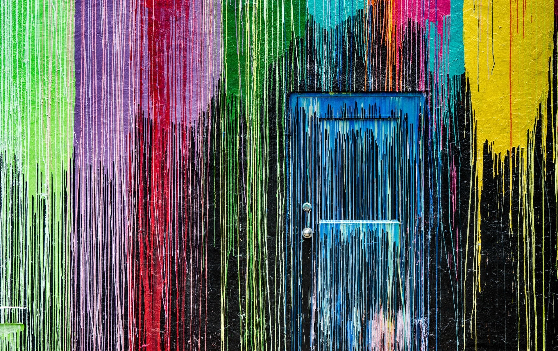 Colorful dripping paint on a wall with a blue door HD Wallpaper