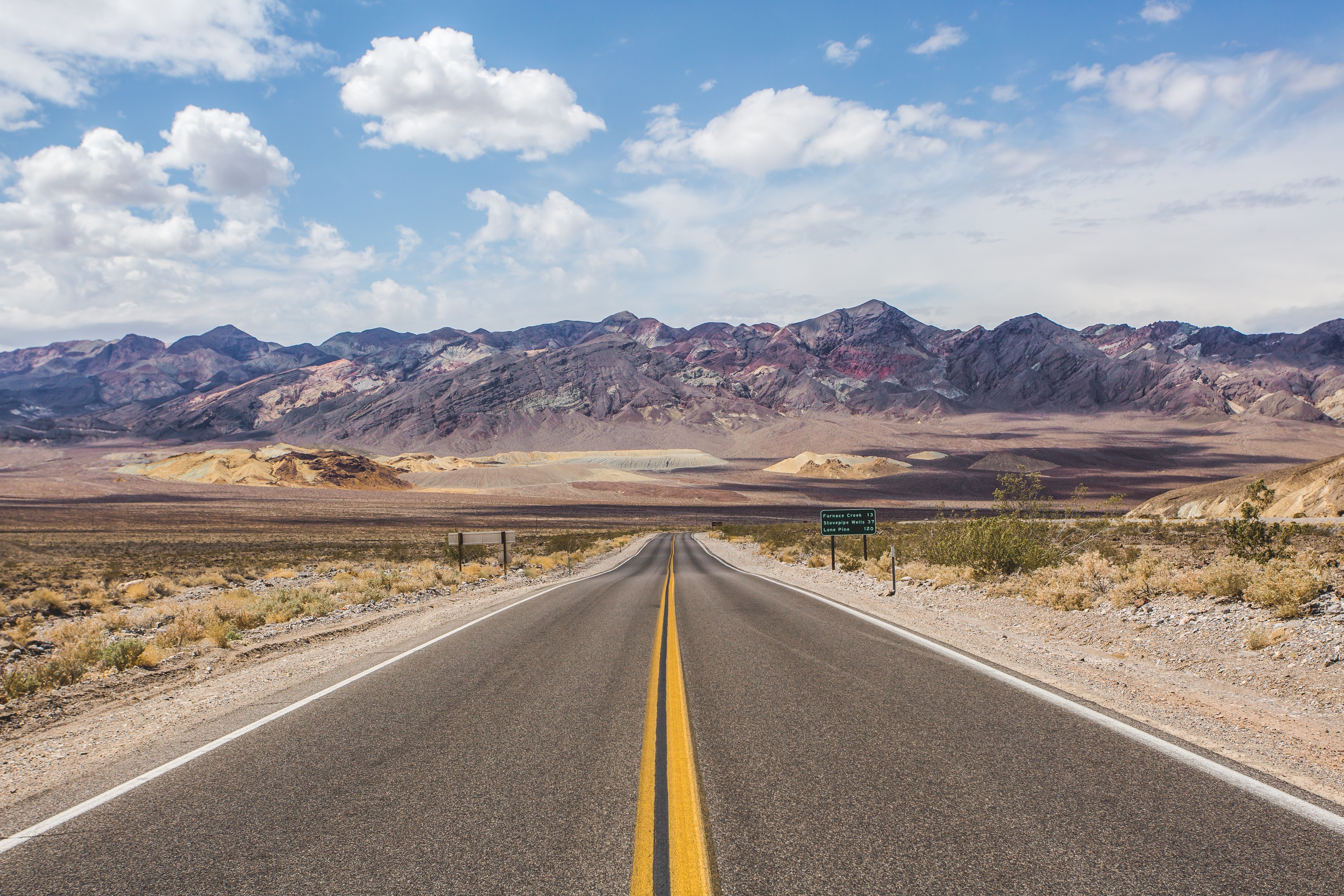 Desert road with mountains and clouds HD Wallpaper