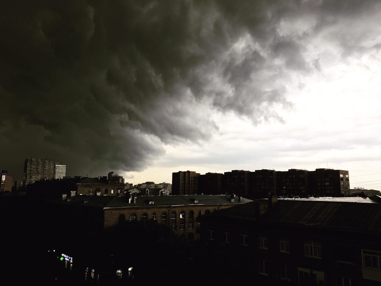 Dark storm clouds over a city skyline HD Wallpaper