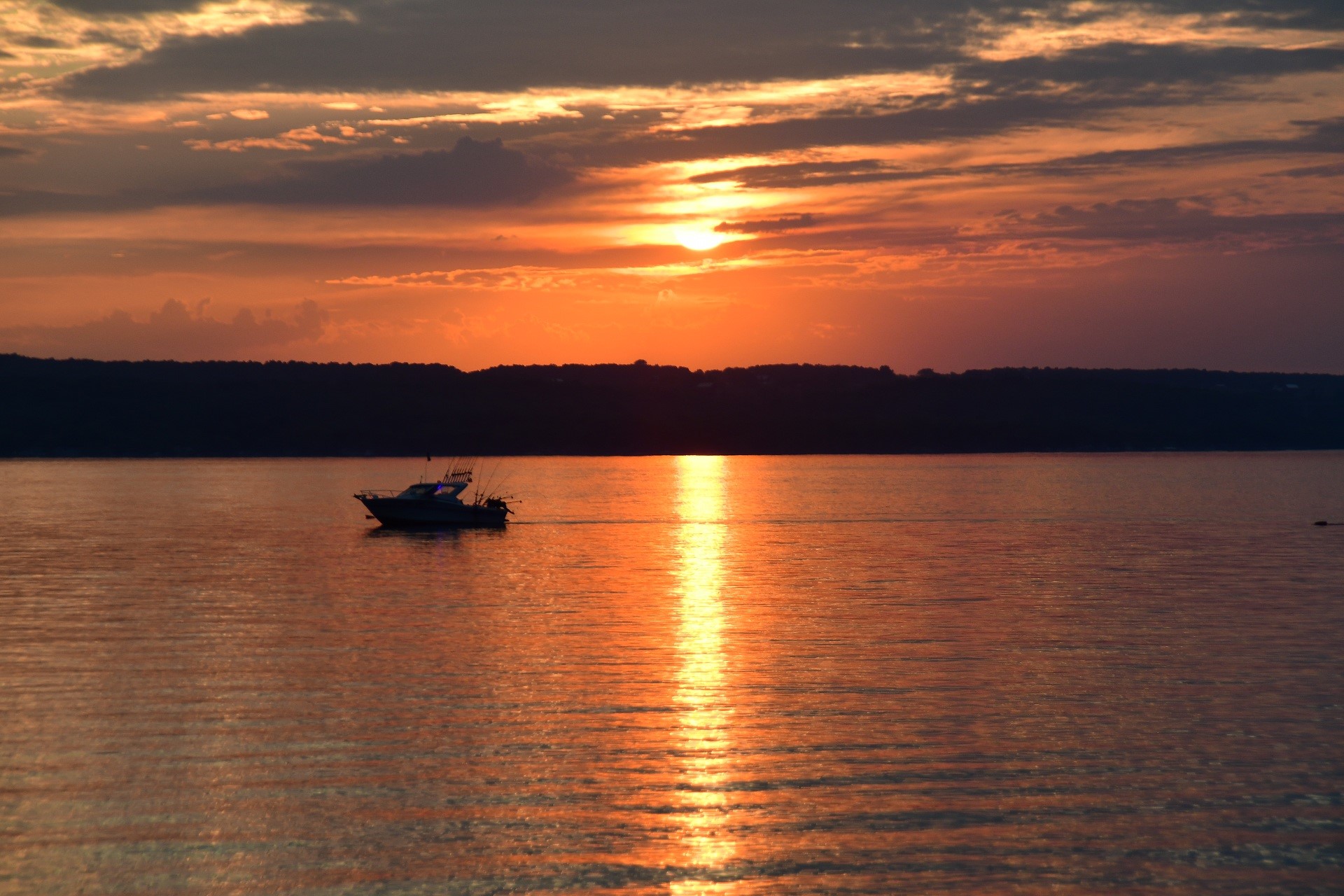 Boat on water during sunset with orange sky HD Wallpaper