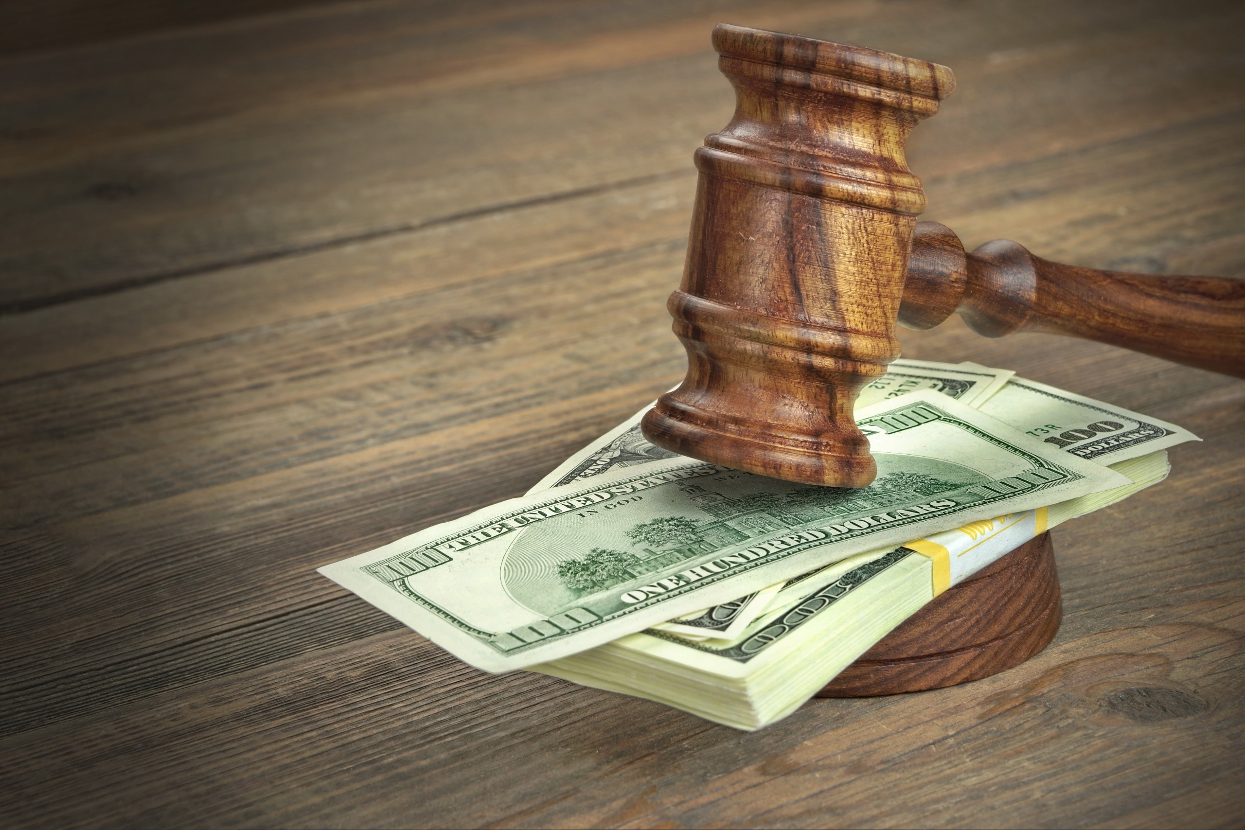 Wooden gavel on a stack of US dollar bills HD Wallpaper