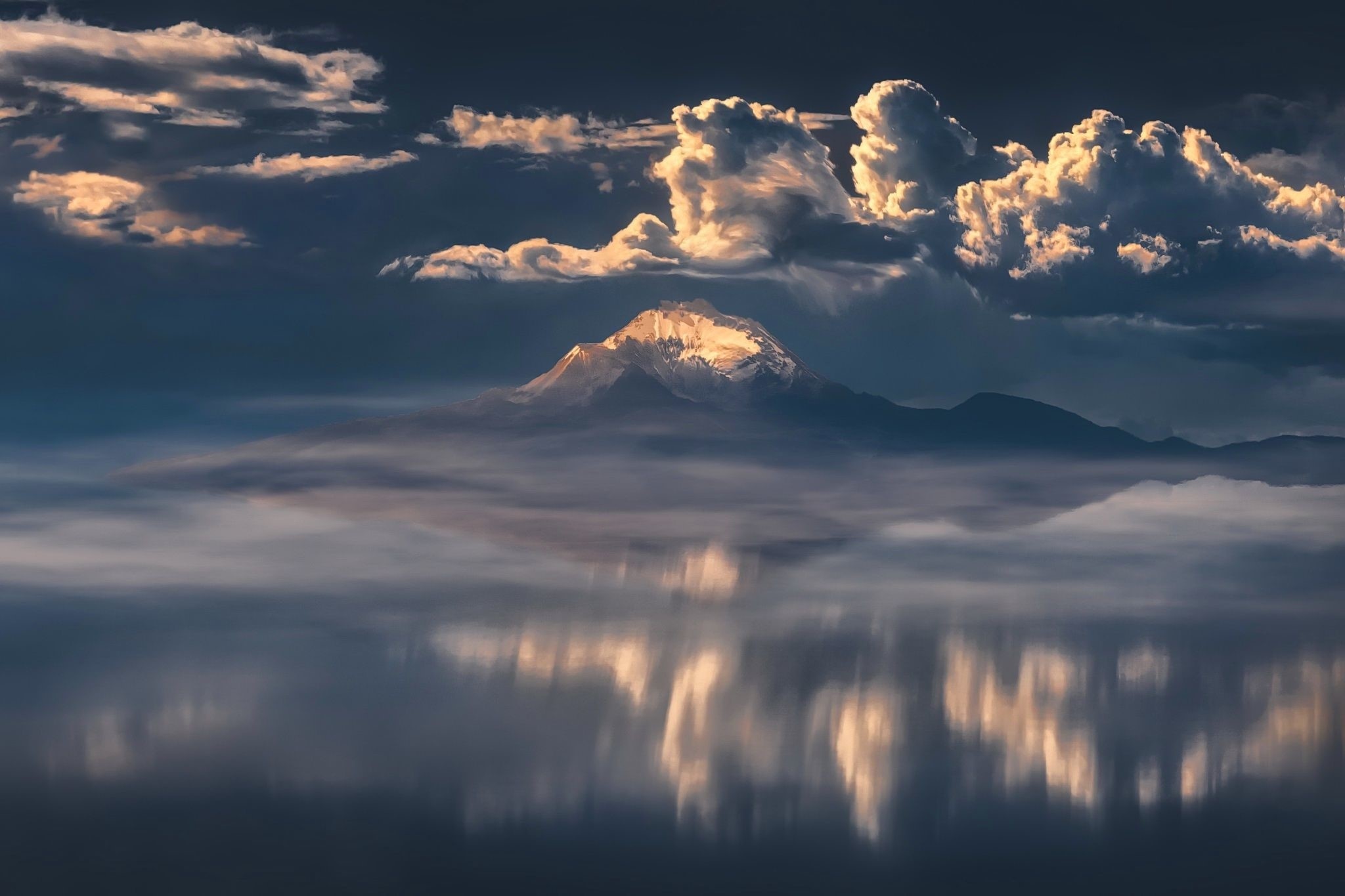 Snow-capped mountain peak above clouds reflected in water HD Wallpaper