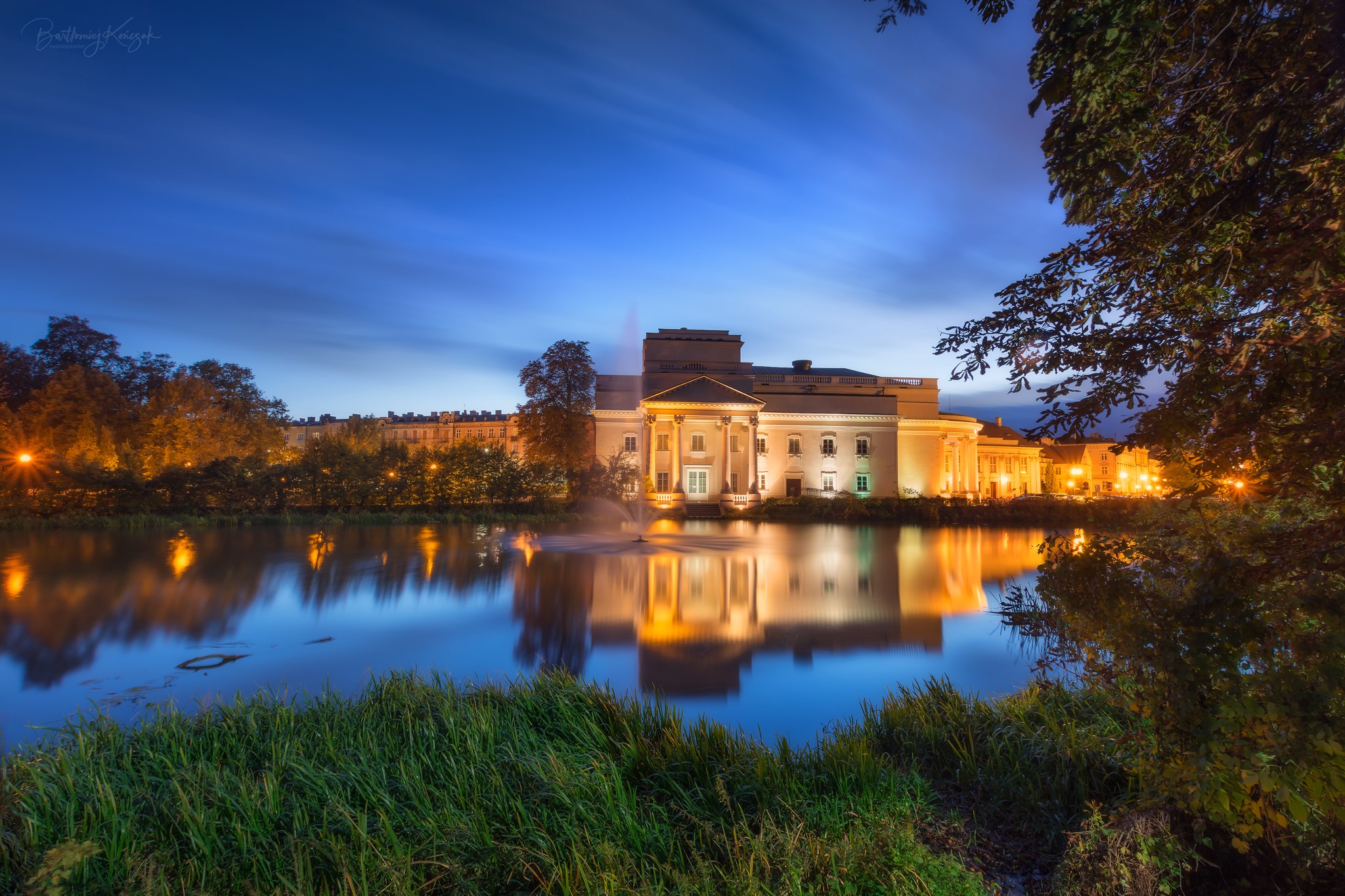 Building reflected in water at night HD Wallpaper