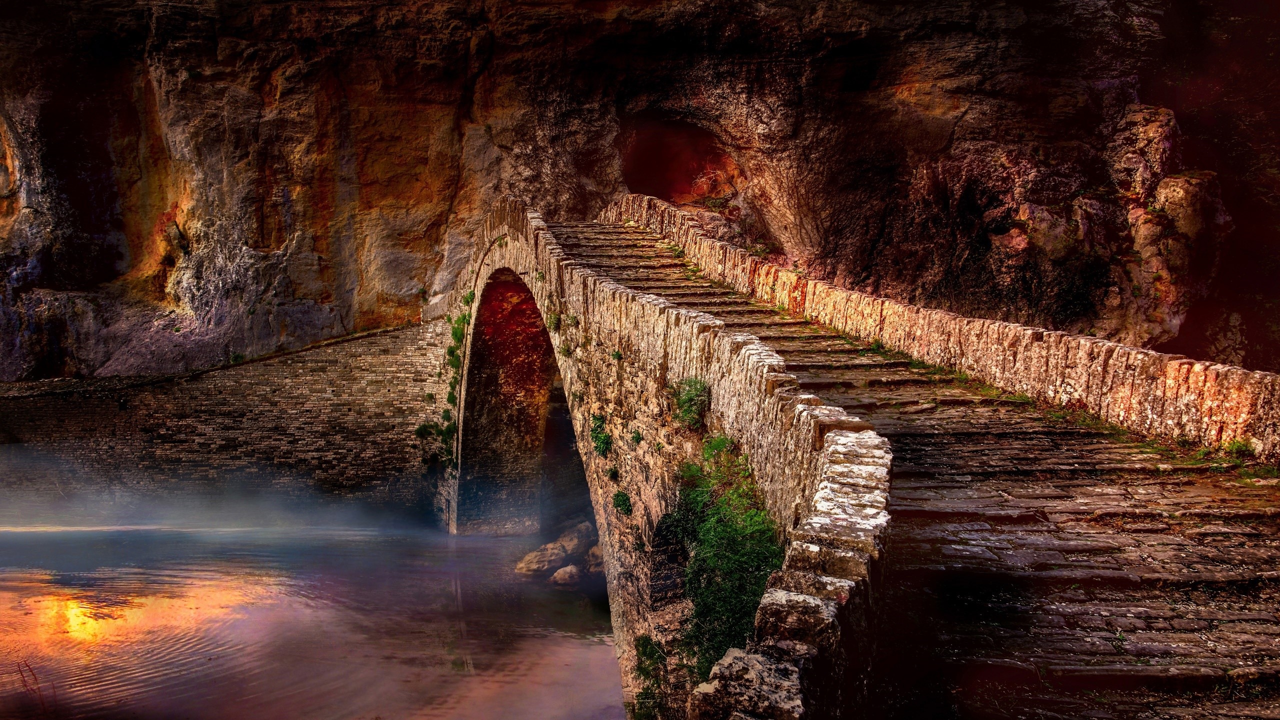 Stone bridge over misty water in a cave HD Wallpaper