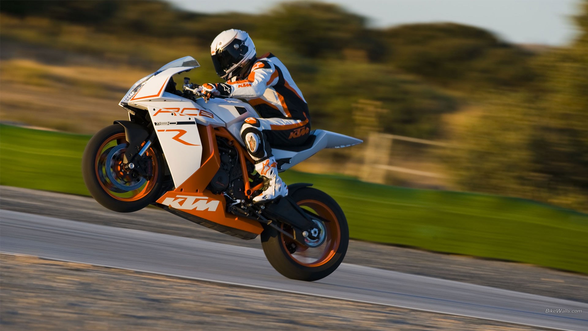 KTM motorcycle doing a wheelie on a track HD Wallpaper