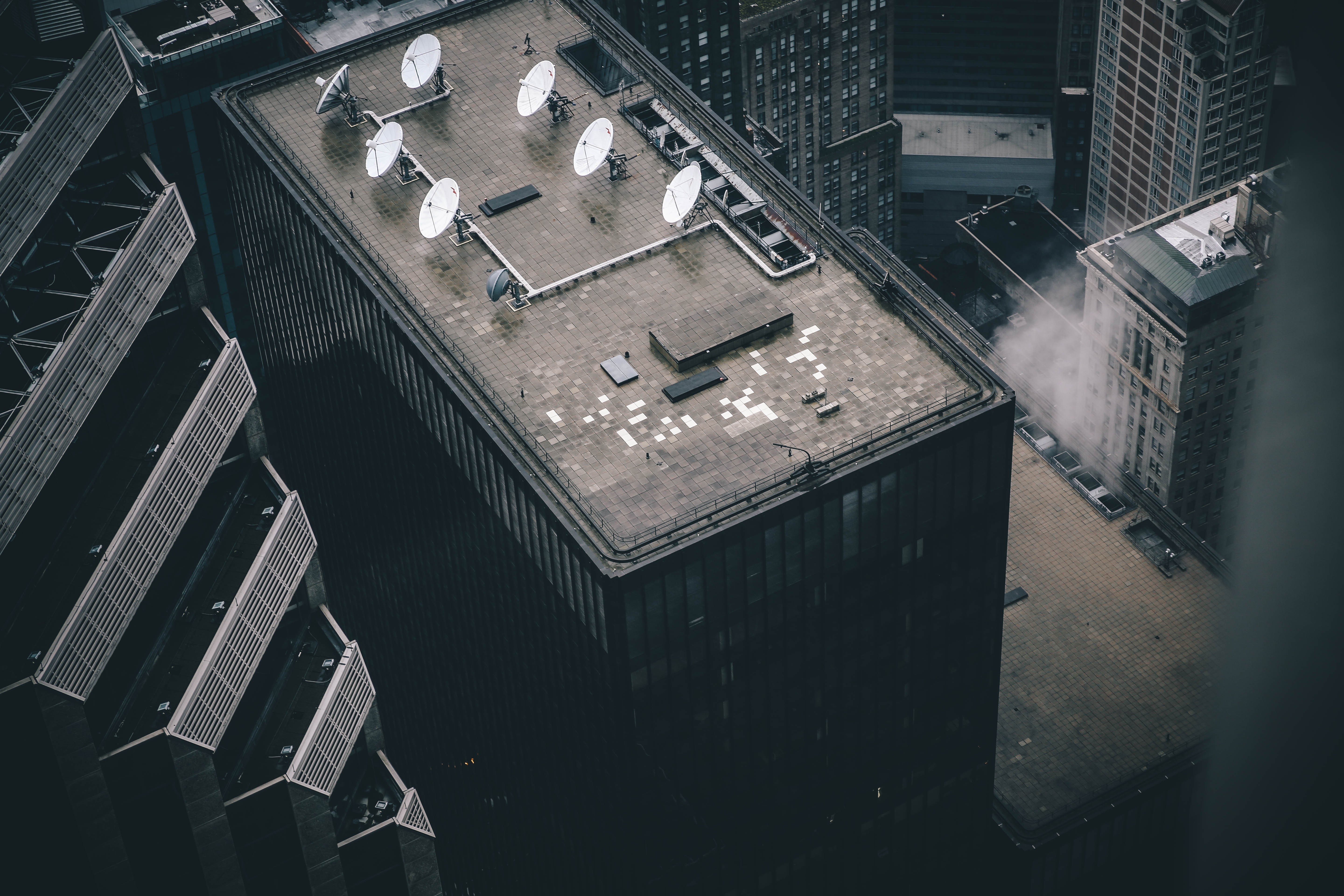 Aerial view of city buildings with satellite dishes HD Wallpaper