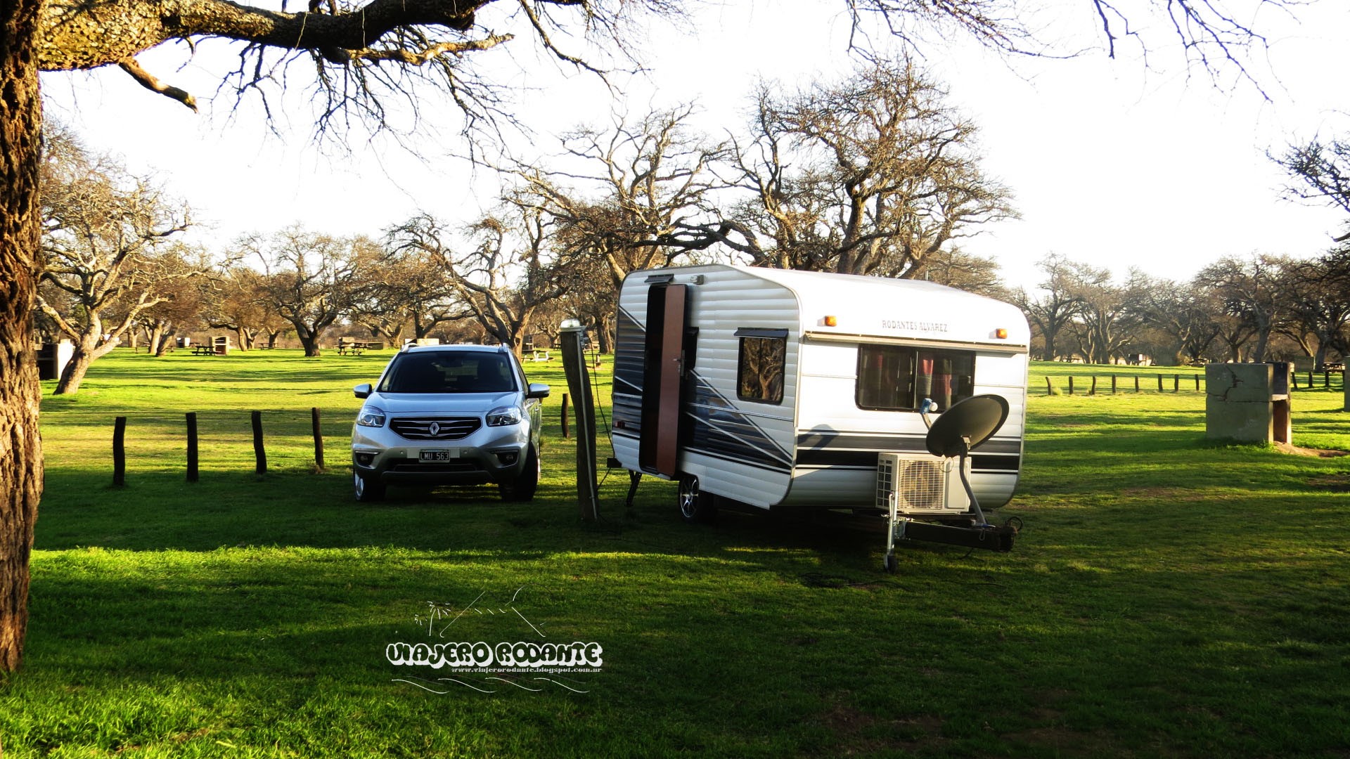 Caravan and SUV parked in a grassy field with trees in Argentina HD Wallpaper