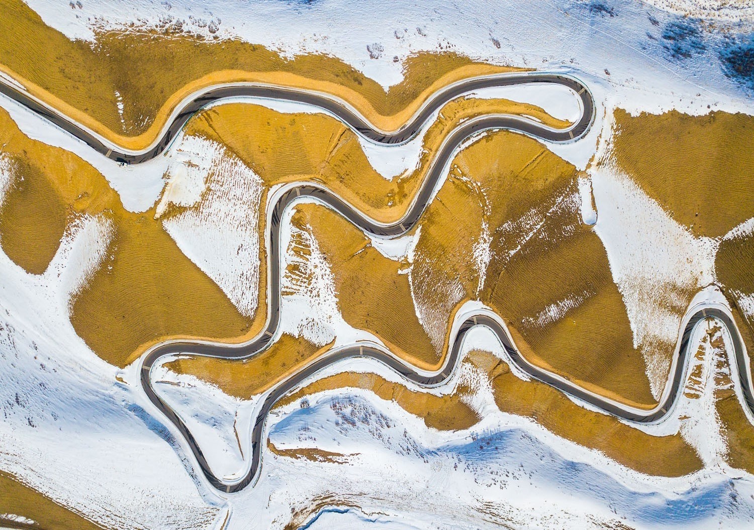 Aerial view of a winding mountain road in winter China HD Wallpaper