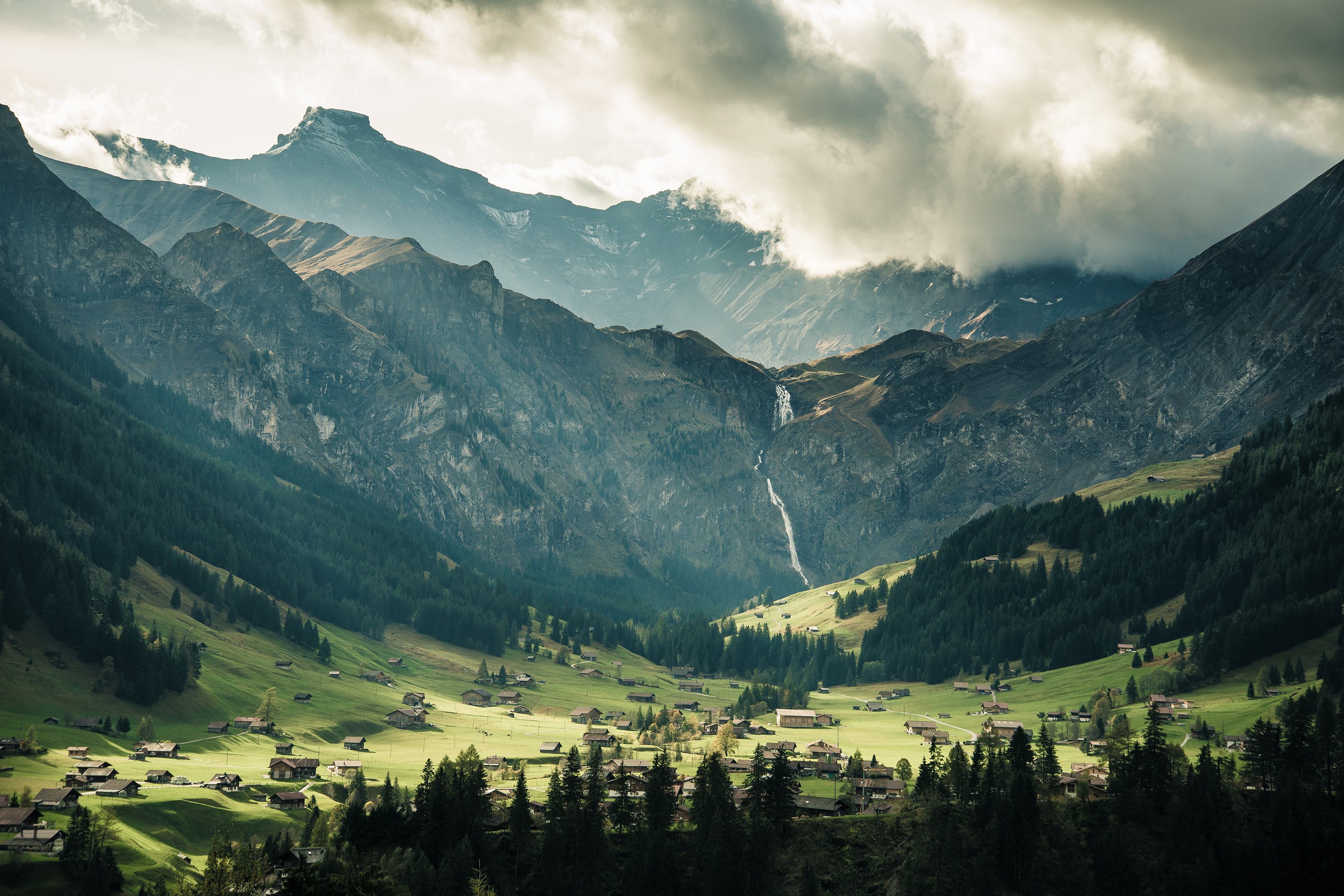 Village in a valley with mountains and waterfall in Switzerland HD Wallpaper