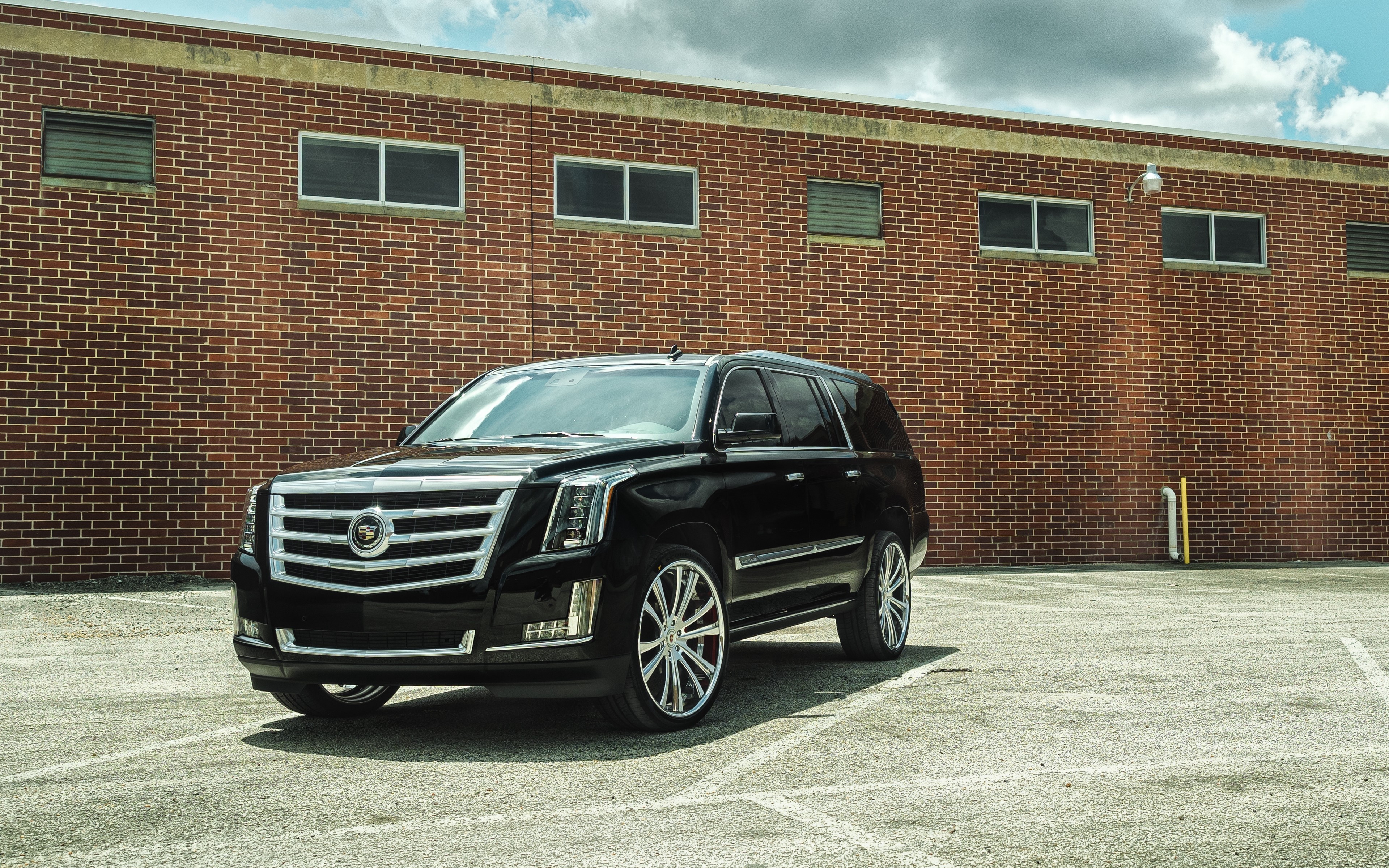 Black Cadillac Escalade parked in front of a brick building HD Wallpaper