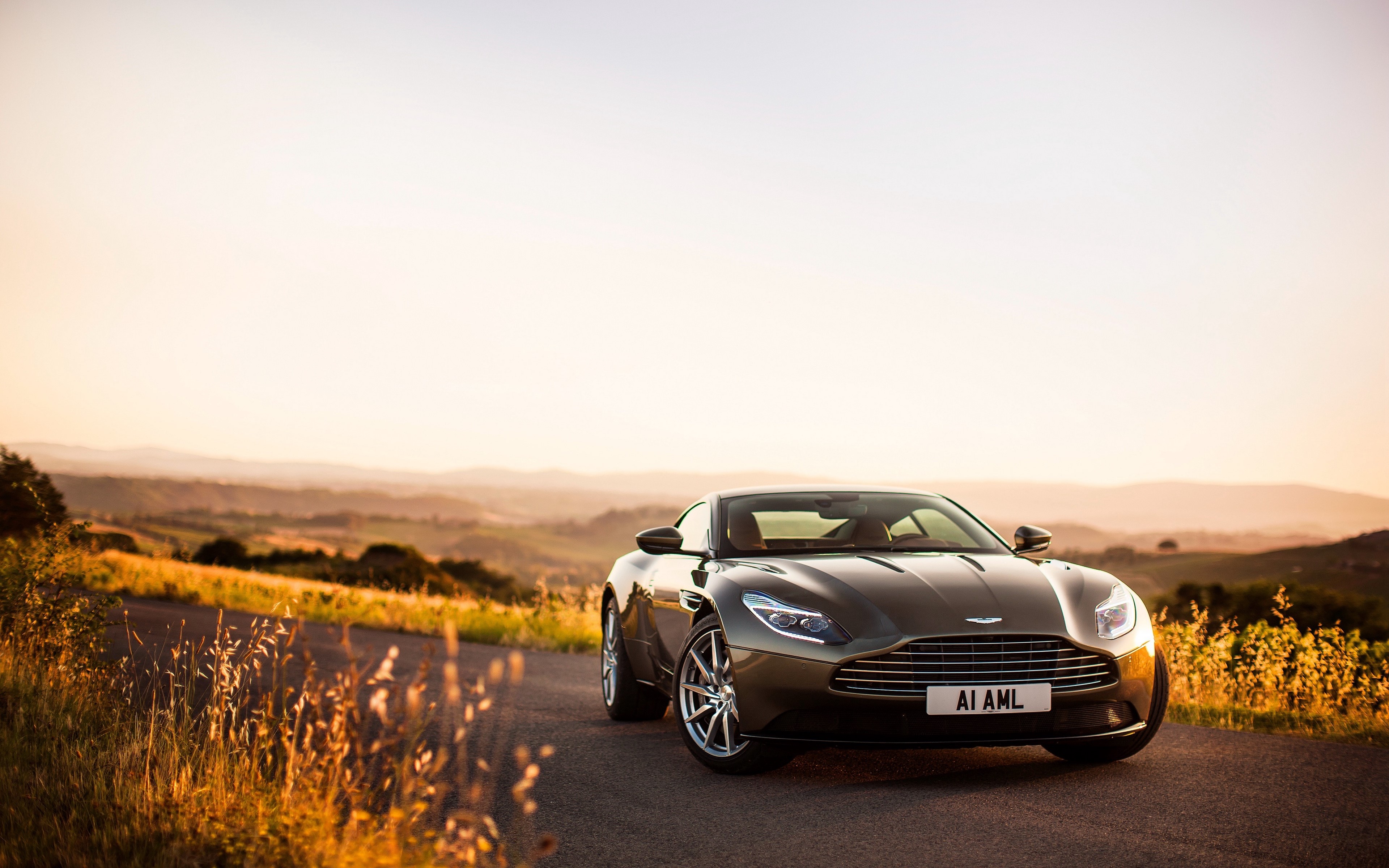 Aston Martin DB11 on a country road at sunset HD Wallpaper