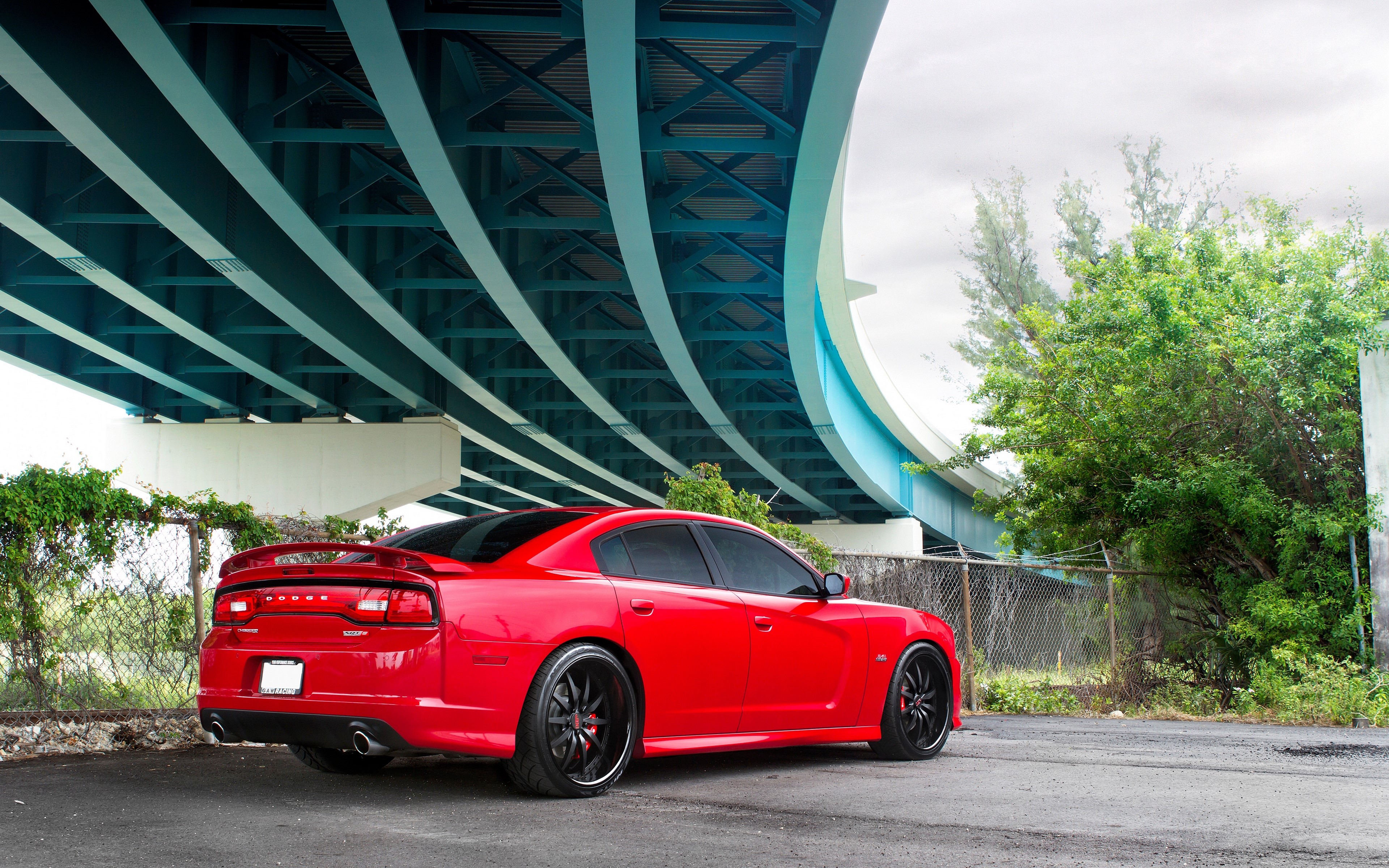 Red Dodge Charger under a blue bridge HD Wallpaper