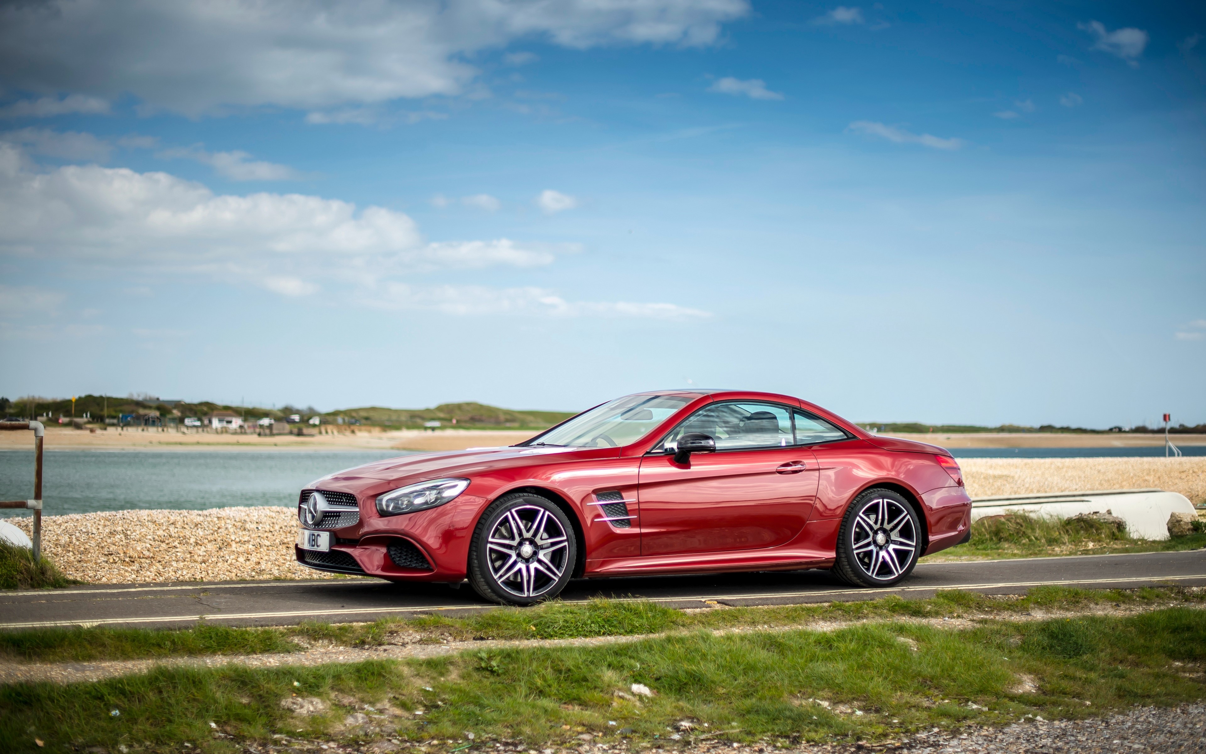 Red Mercedes Benz SL car on a road by the sea HD Wallpaper