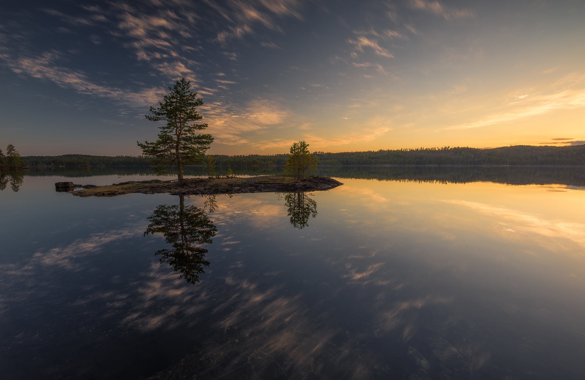 Island with trees reflected in calm lake at sunset HD Wallpaper