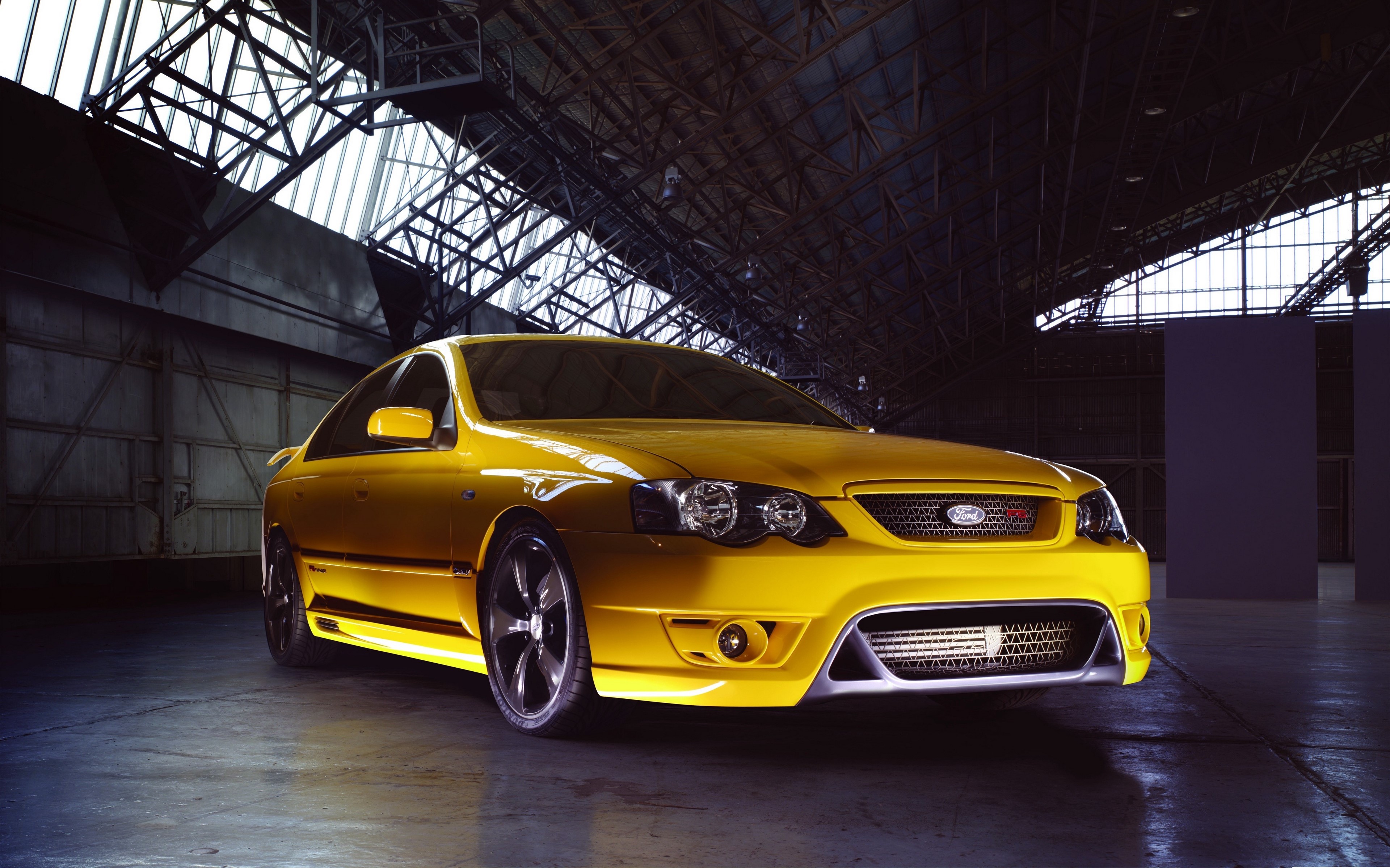 Yellow Ford Falcon sports sedan in a warehouse HD Wallpaper