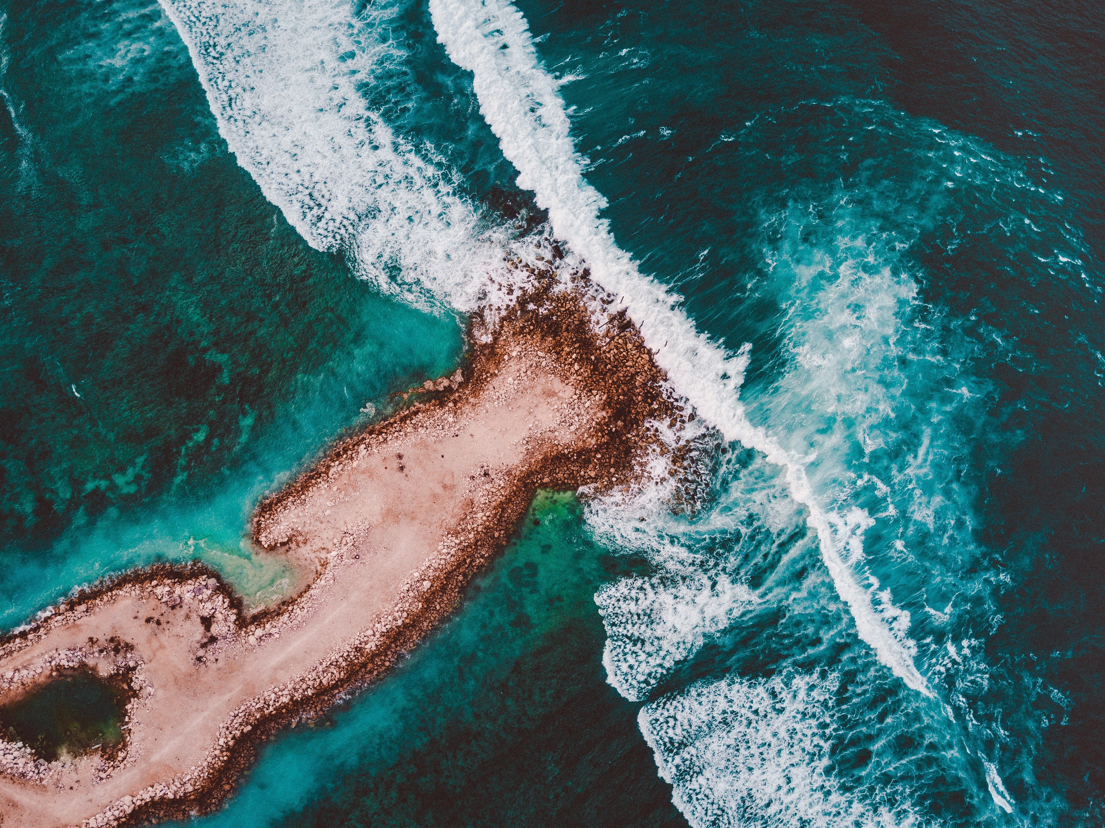 Aerial view of waves crashing on a rocky shore HD Wallpaper