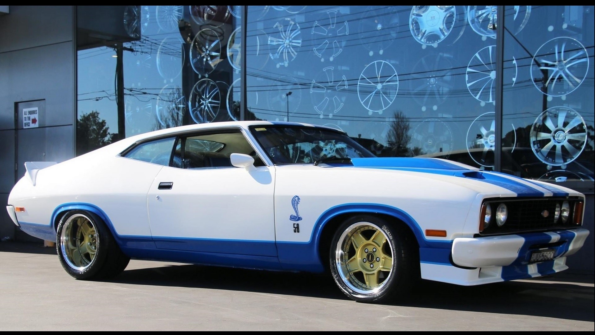 White Ford XB Coupe with blue racing stripes and gold wheels HD Wallpaper
