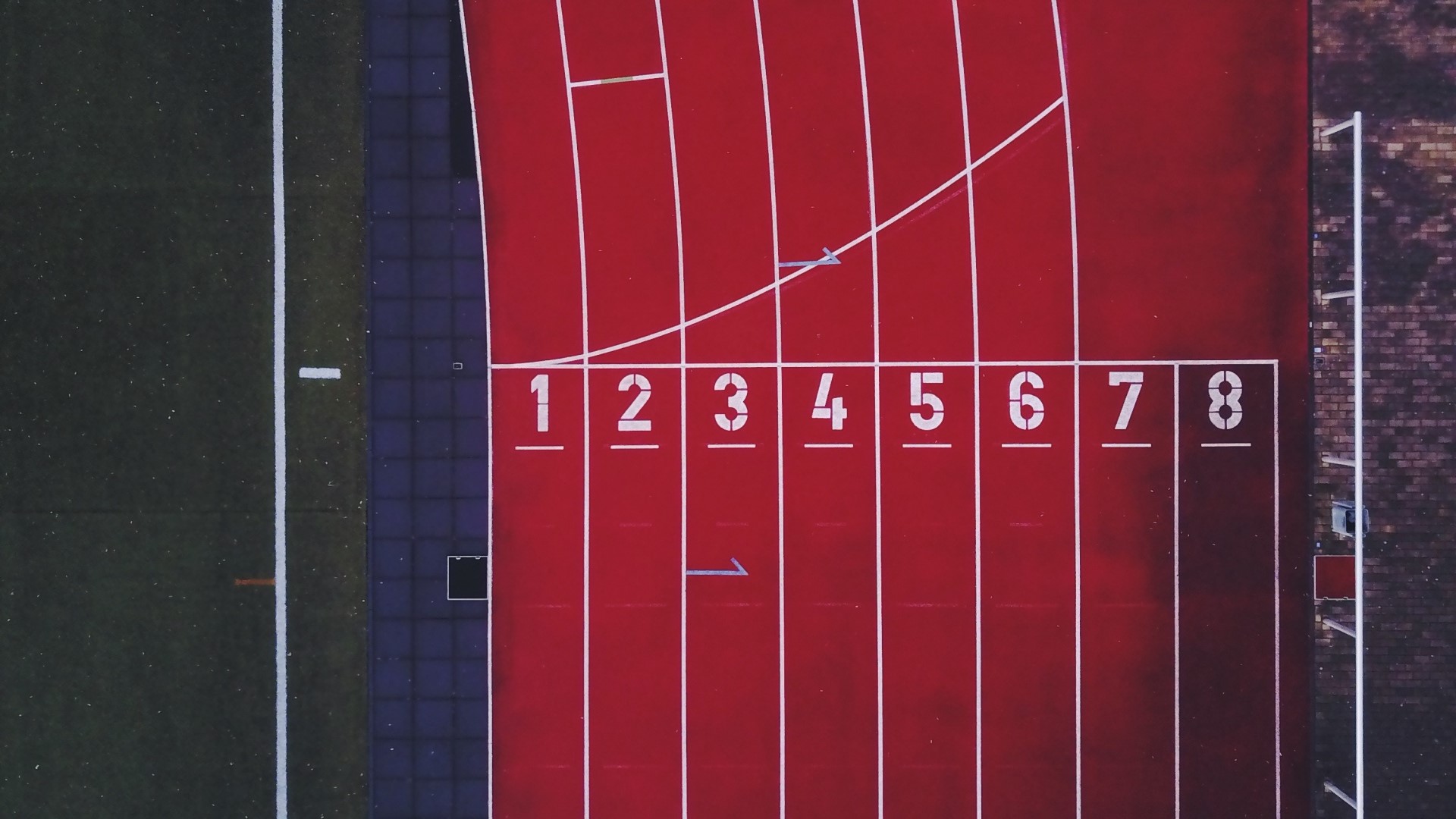 Aerial view of a running track with numbered lanes HD Wallpaper