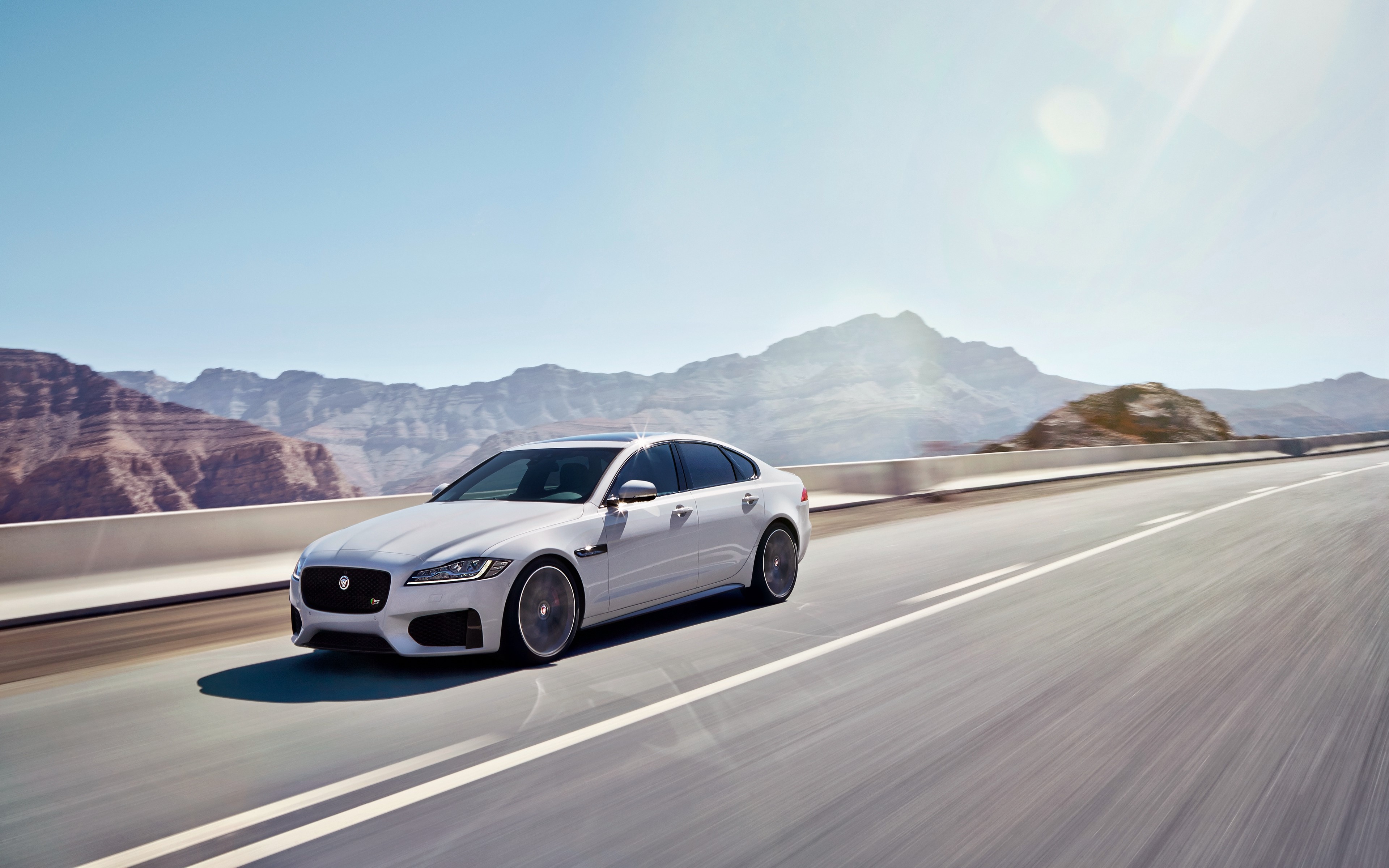 White Jaguar XF Sedan on a Desert Road HD Wallpaper