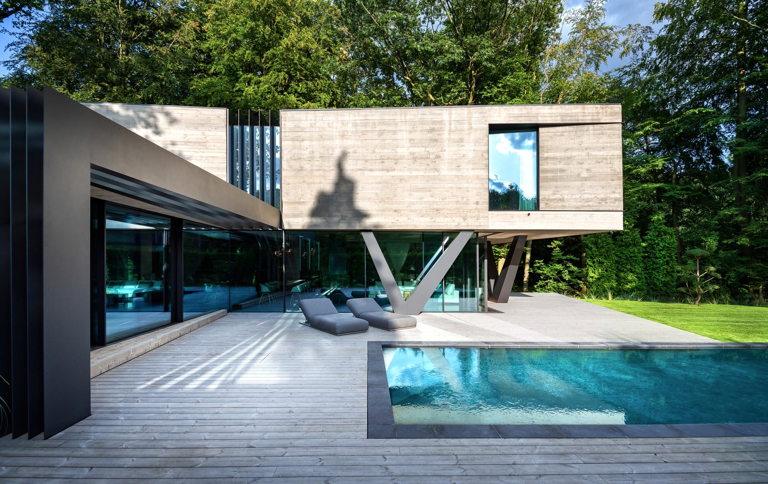 Modern concrete house with swimming pool and lounge chairs HD Wallpaper