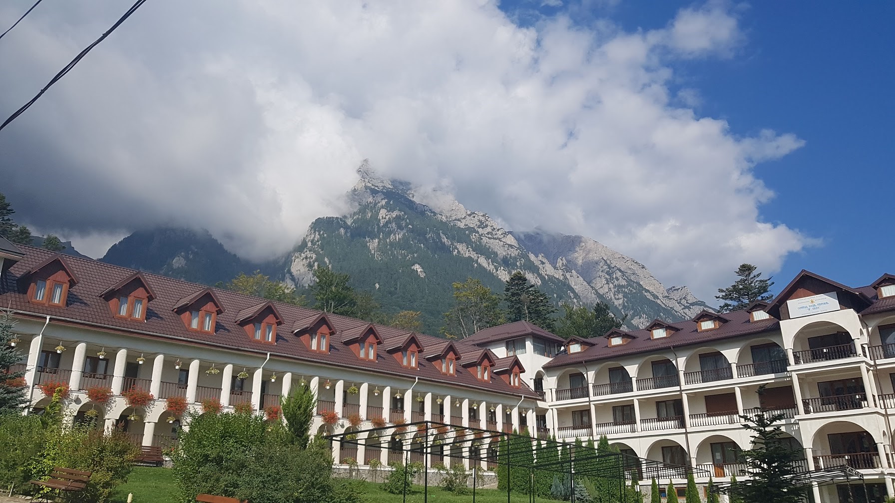 Hotel buildings with mountains in the background in Romania HD Wallpaper