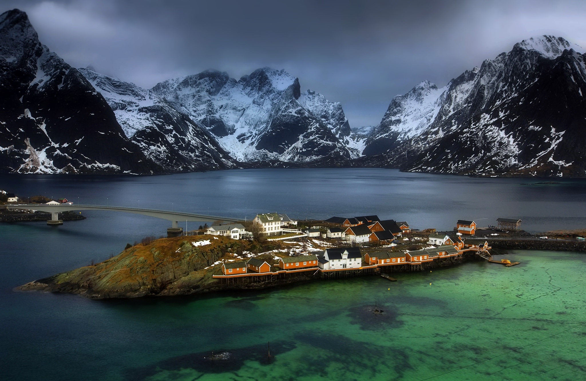 Village on island with snow-capped mountains and bridge in Norway HD Wallpaper